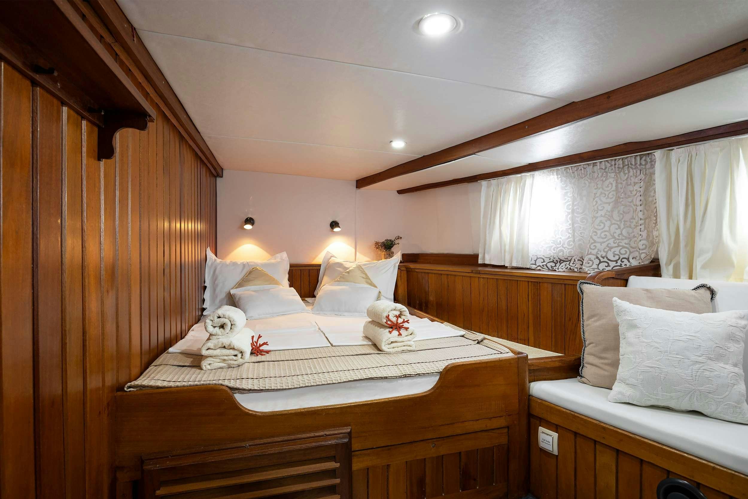 a bed with a stuffed animal aboard ABORDA Yacht for Charter