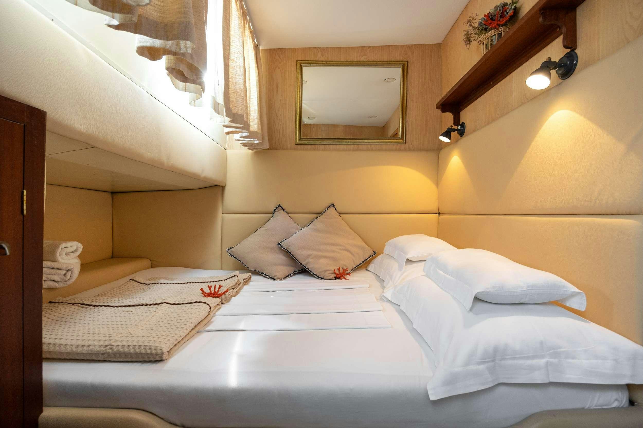 a bed with white sheets aboard ABORDA Yacht for Charter