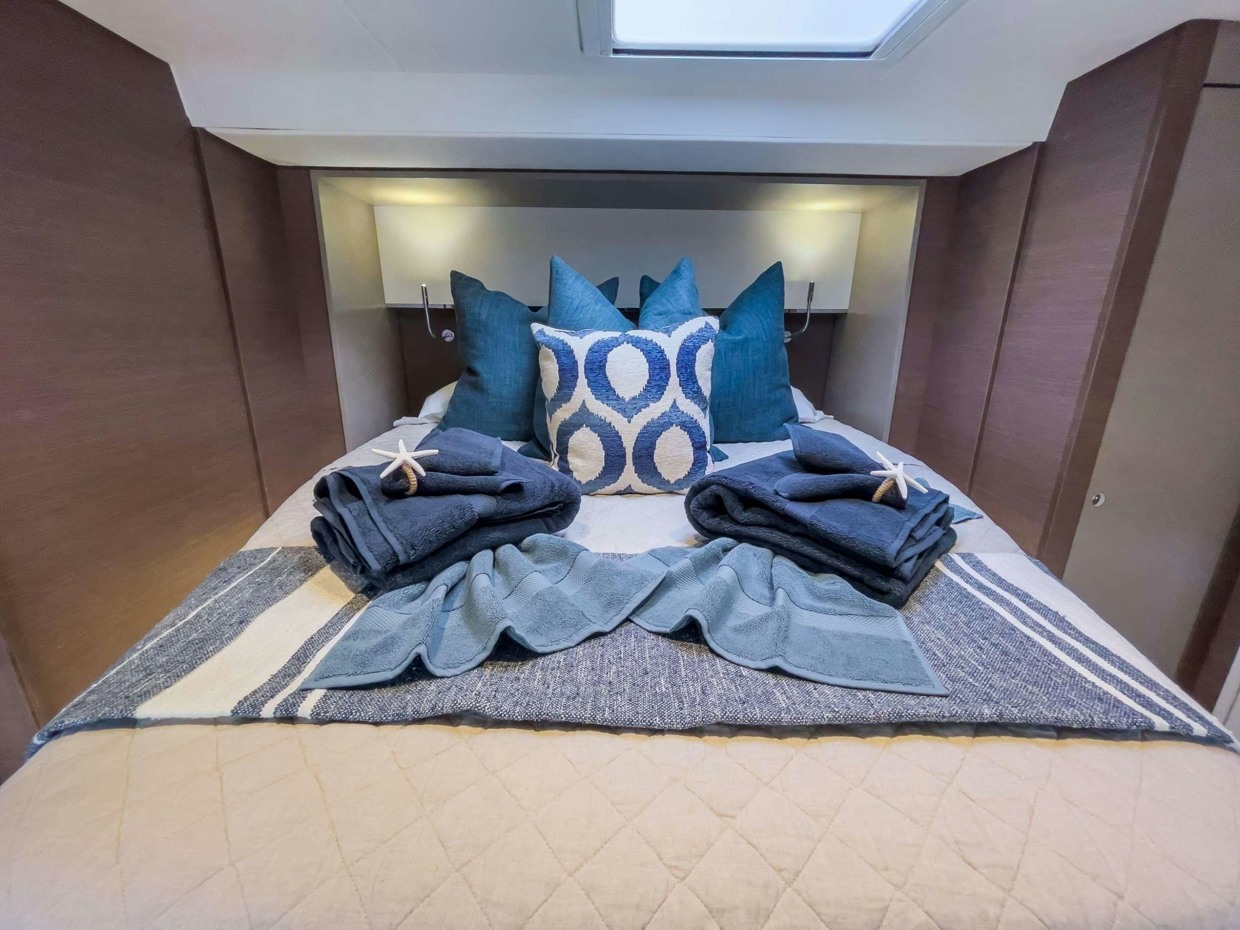 a bed with blue pillows aboard ANNA PINK Yacht for Charter