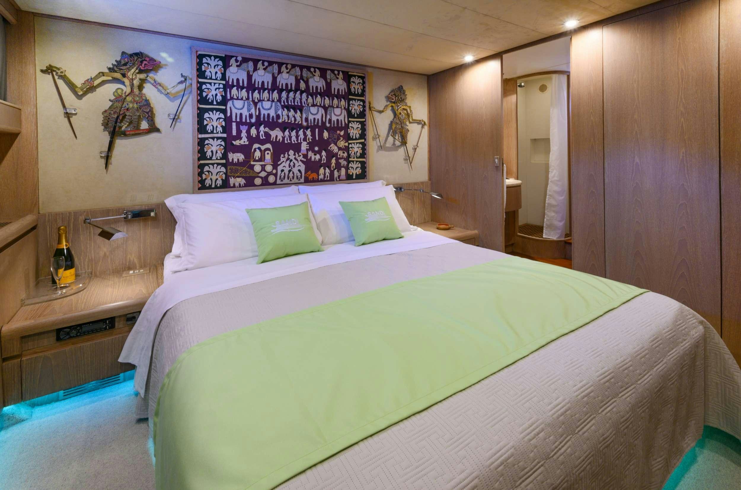 a bed with green and white sheets aboard SANDI IV Yacht for Charter