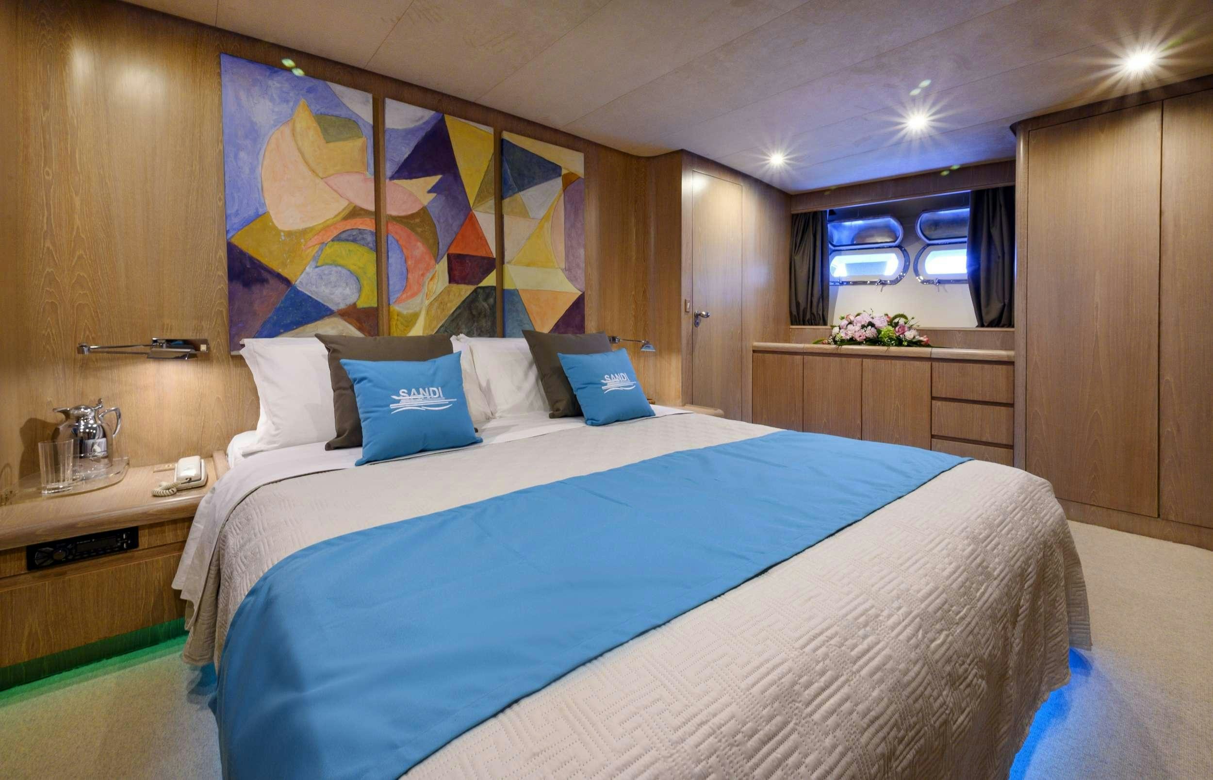 a bed with blue sheets aboard SANDI IV Yacht for Charter