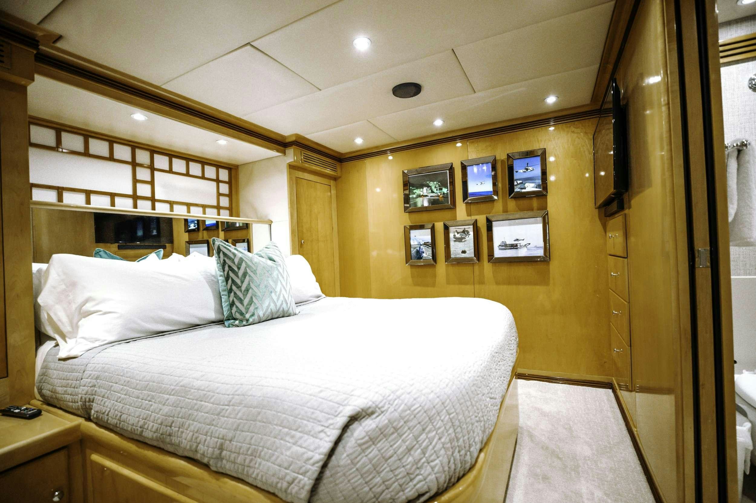a bedroom with a bed and a desk aboard READY II PLAY Yacht for Charter