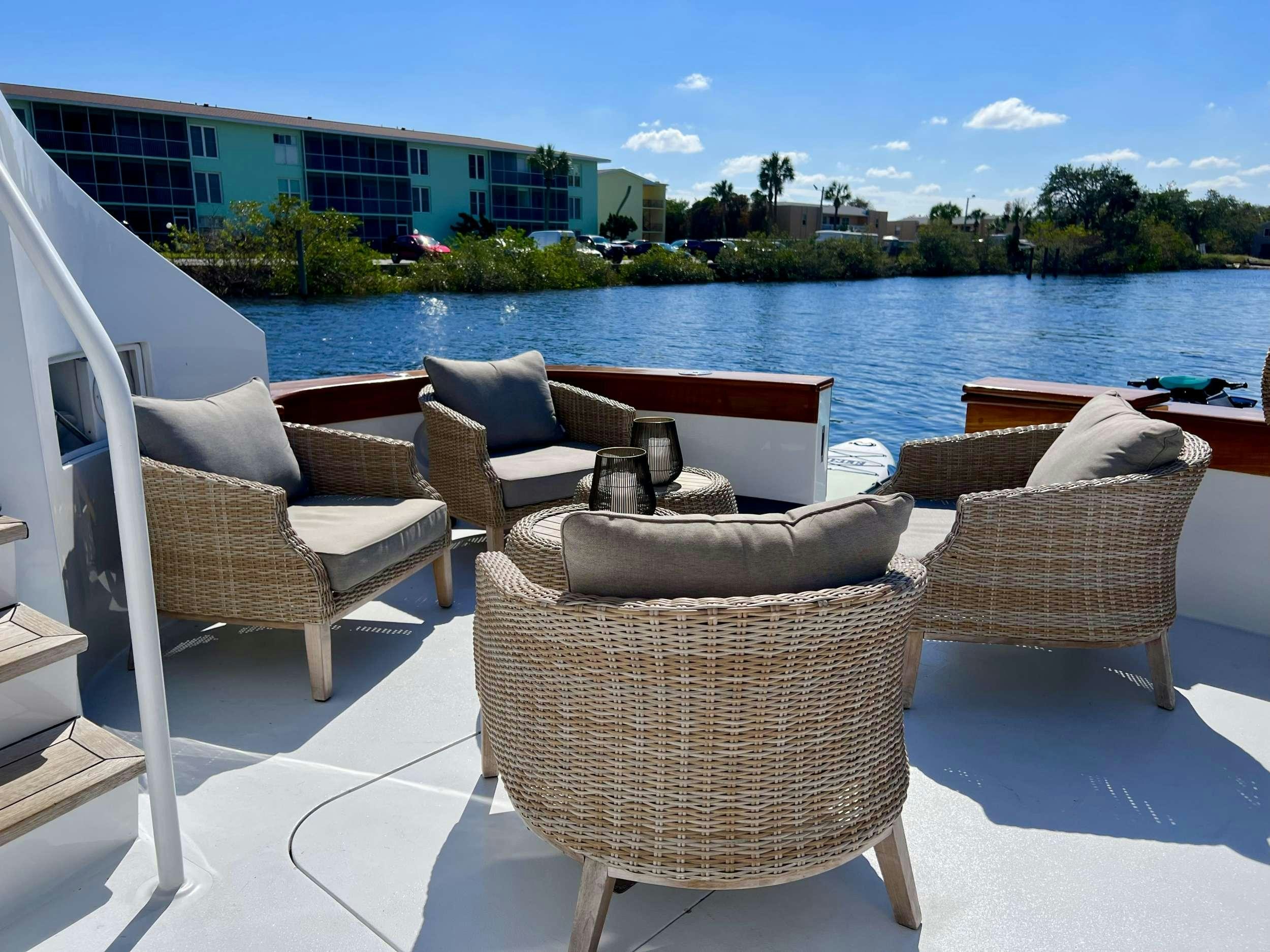a group of chairs on a deck overlooking a body of water aboard READY II PLAY Yacht for Charter