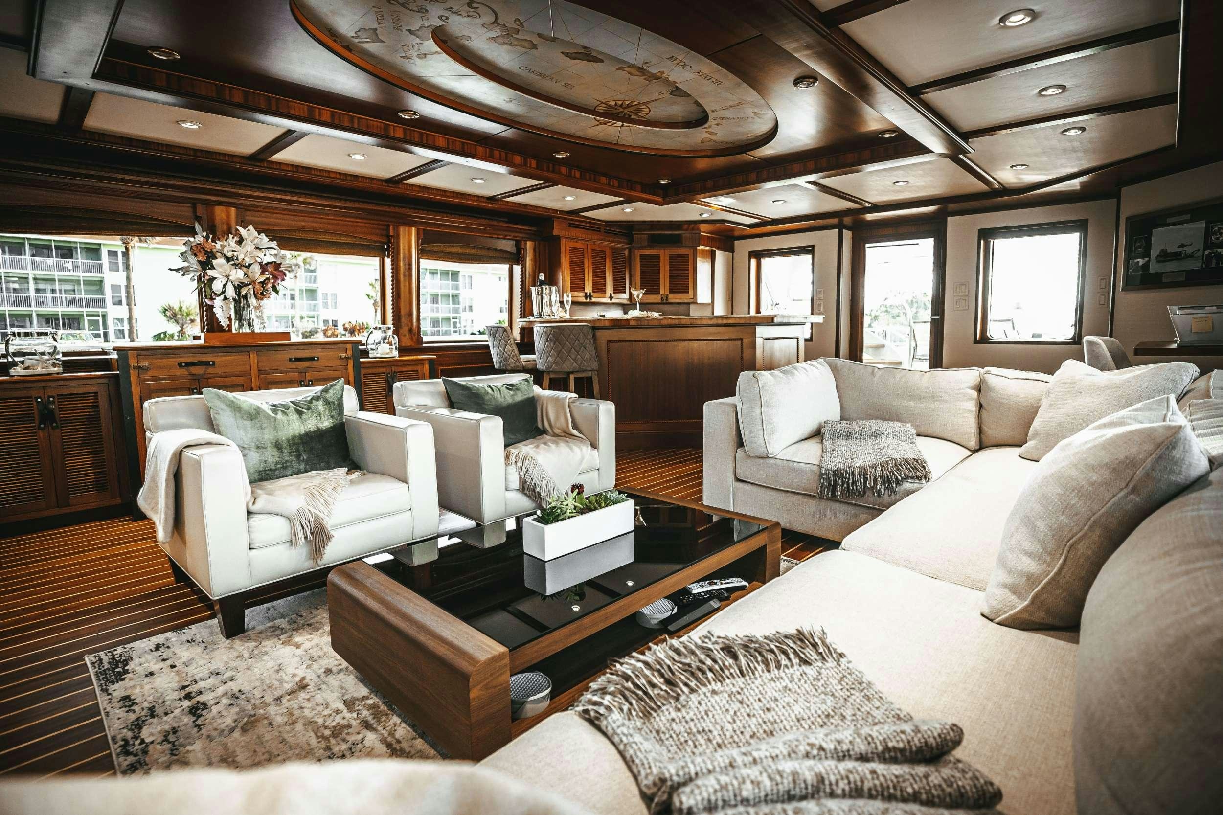 a living room with a large sofa and a coffee table aboard READY II PLAY Yacht for Charter