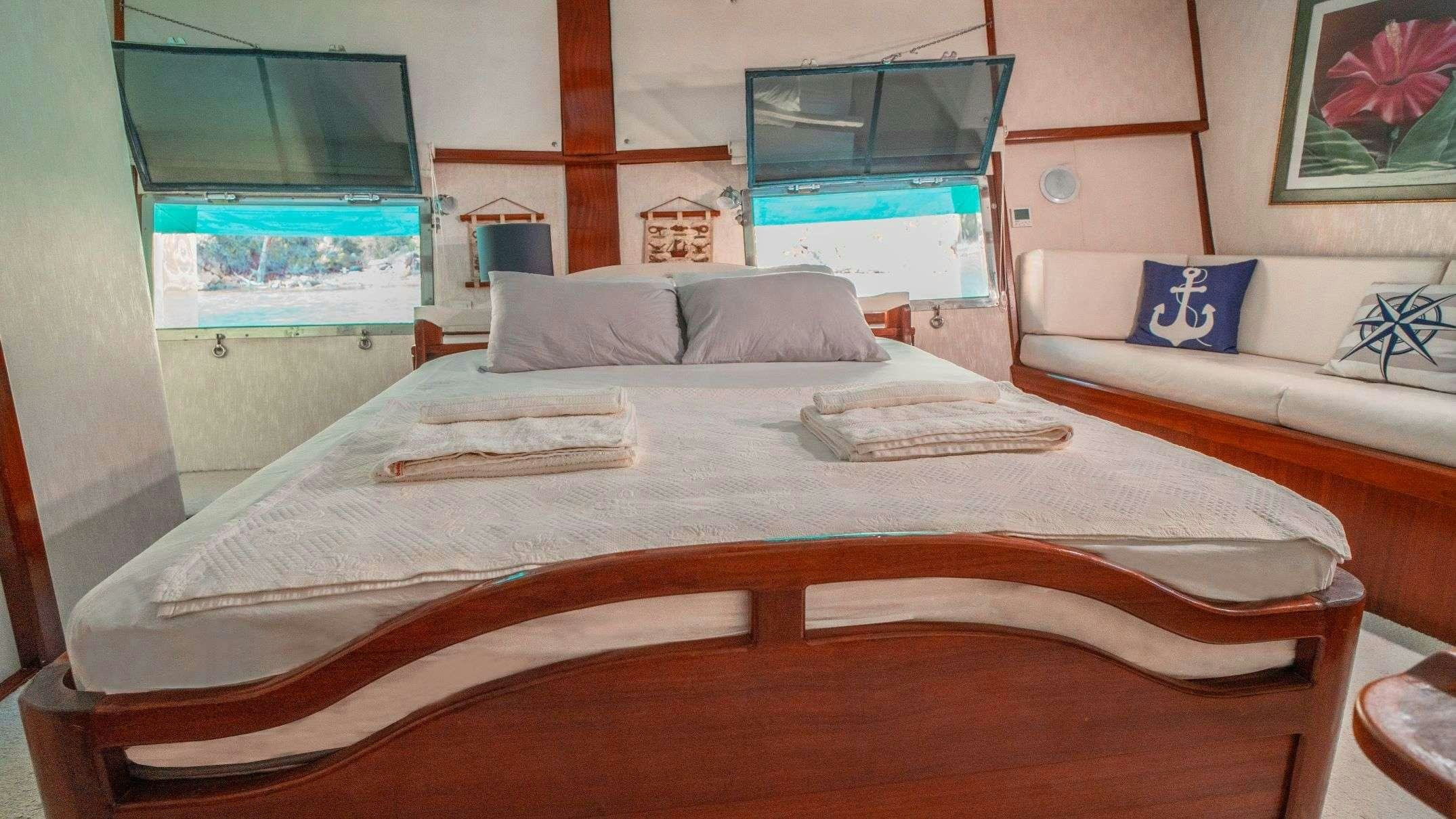 a bed with a white sheet and pillows aboard WHITE SWAN Yacht for Charter