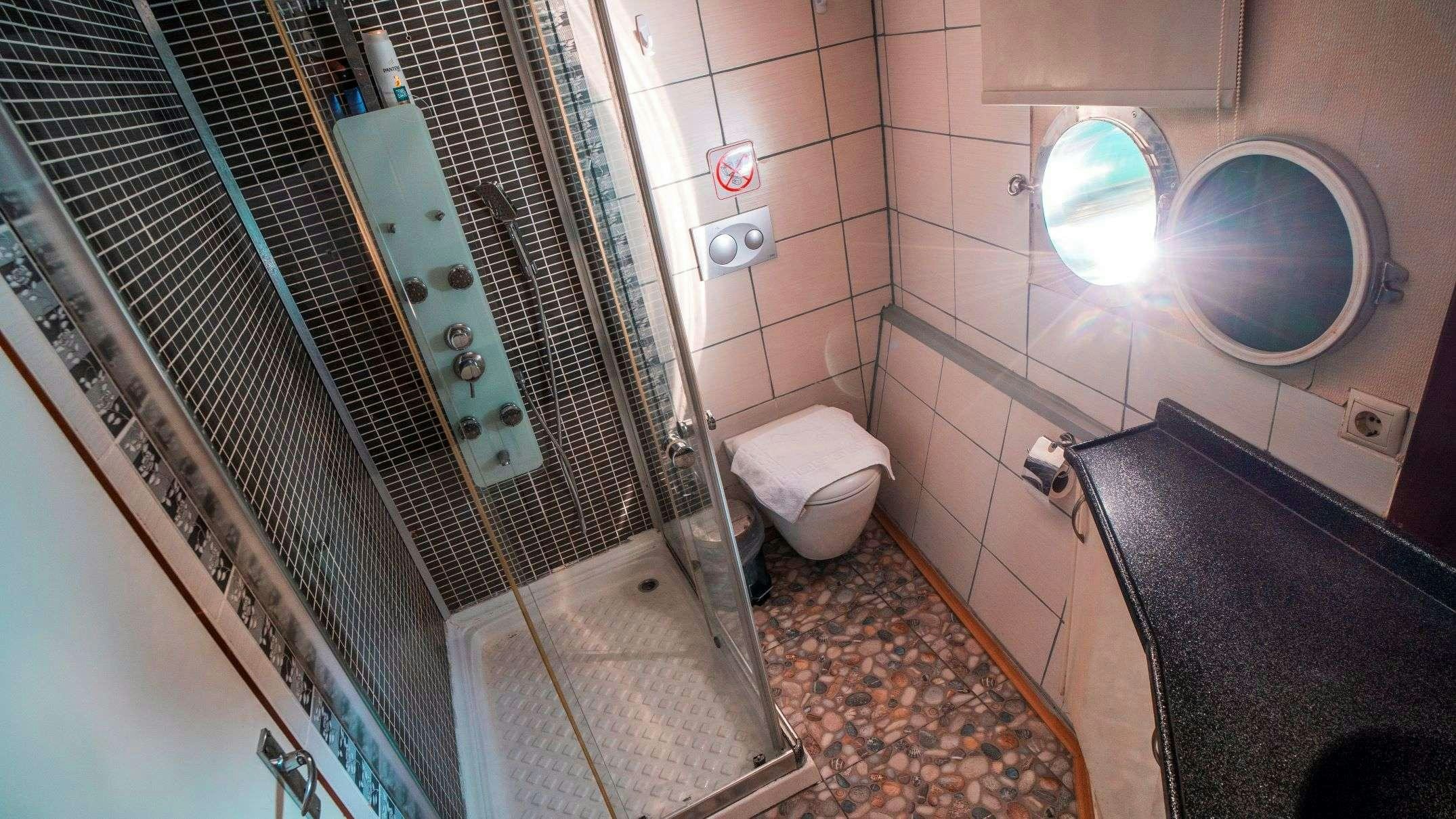 a bathroom with a glass shower aboard WHITE SWAN Yacht for Charter