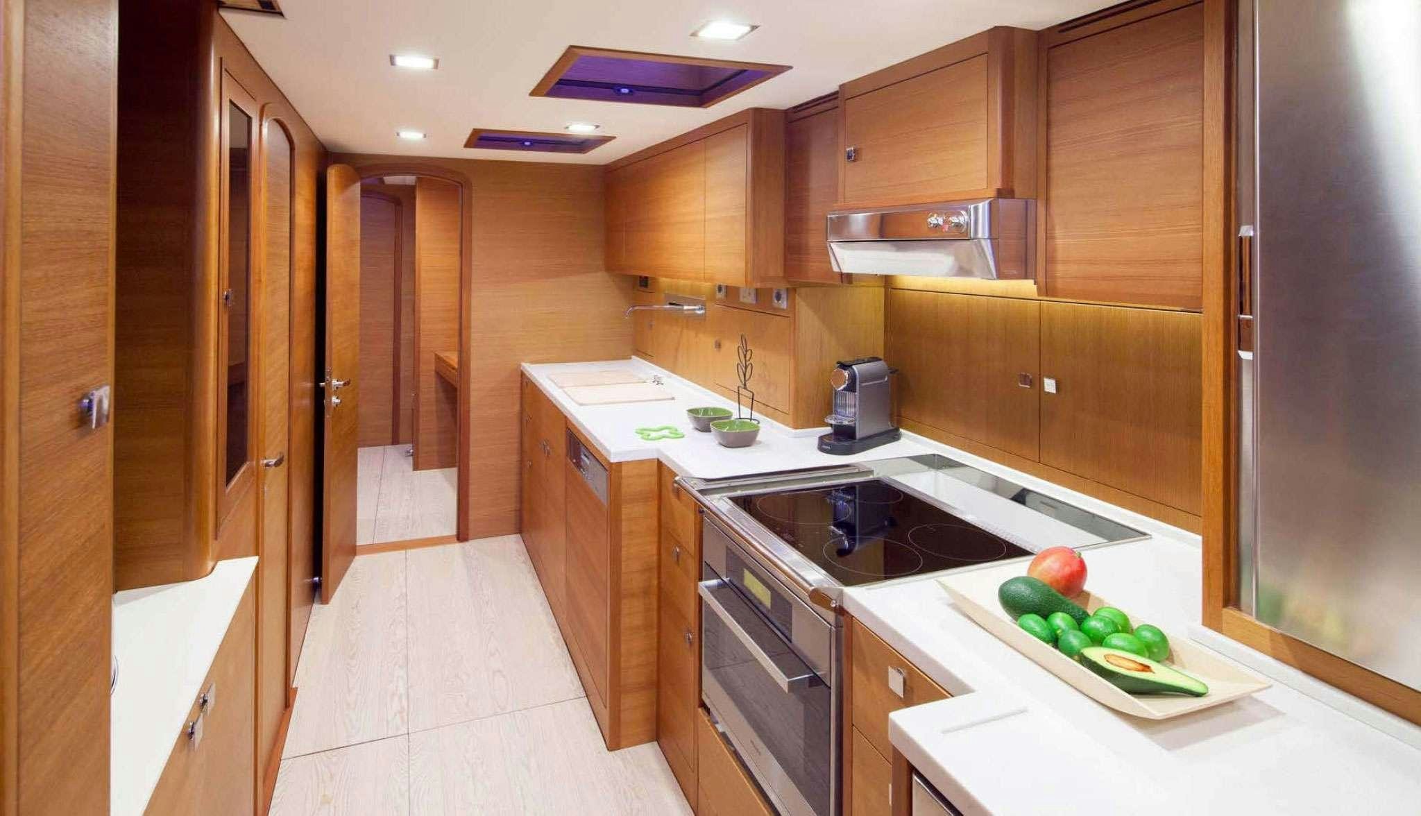 a kitchen with wooden cabinets aboard SOLARIS 72 Yacht for Charter