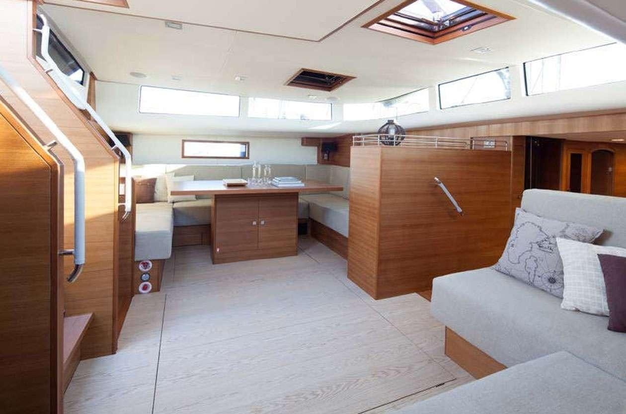 a room with a couch and a desk aboard SOLARIS 72 Yacht for Charter