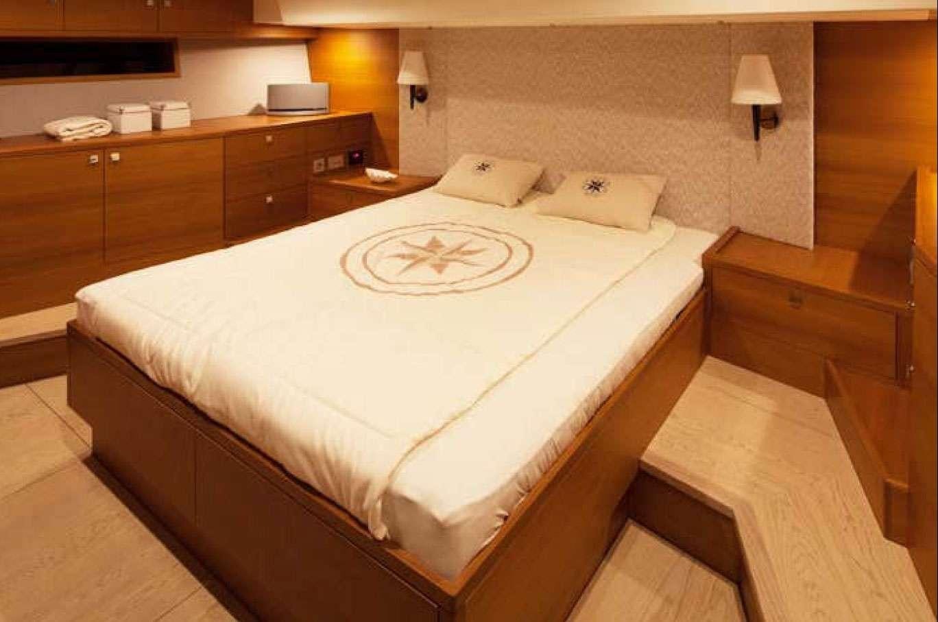 a bed with white sheets aboard SOLARIS 72 Yacht for Charter