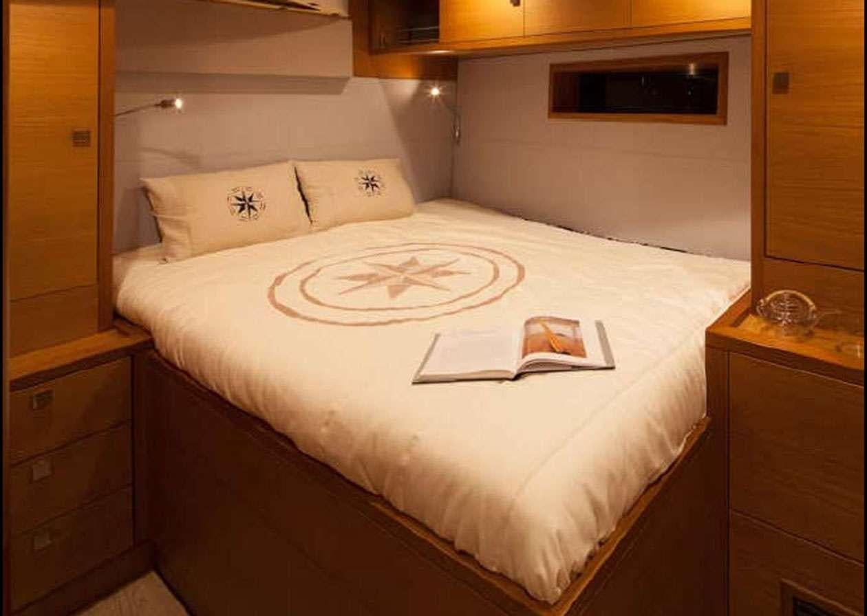 a bed with a white sheet and a white pillow aboard SOLARIS 72 Yacht for Charter