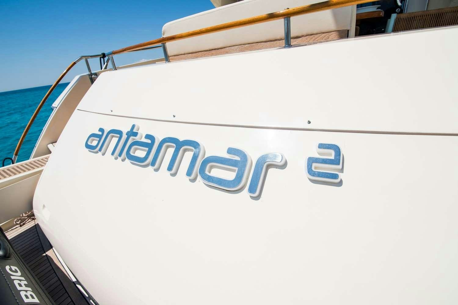 a white boat with a blue sign aboard ANTAMAR II Yacht for Charter