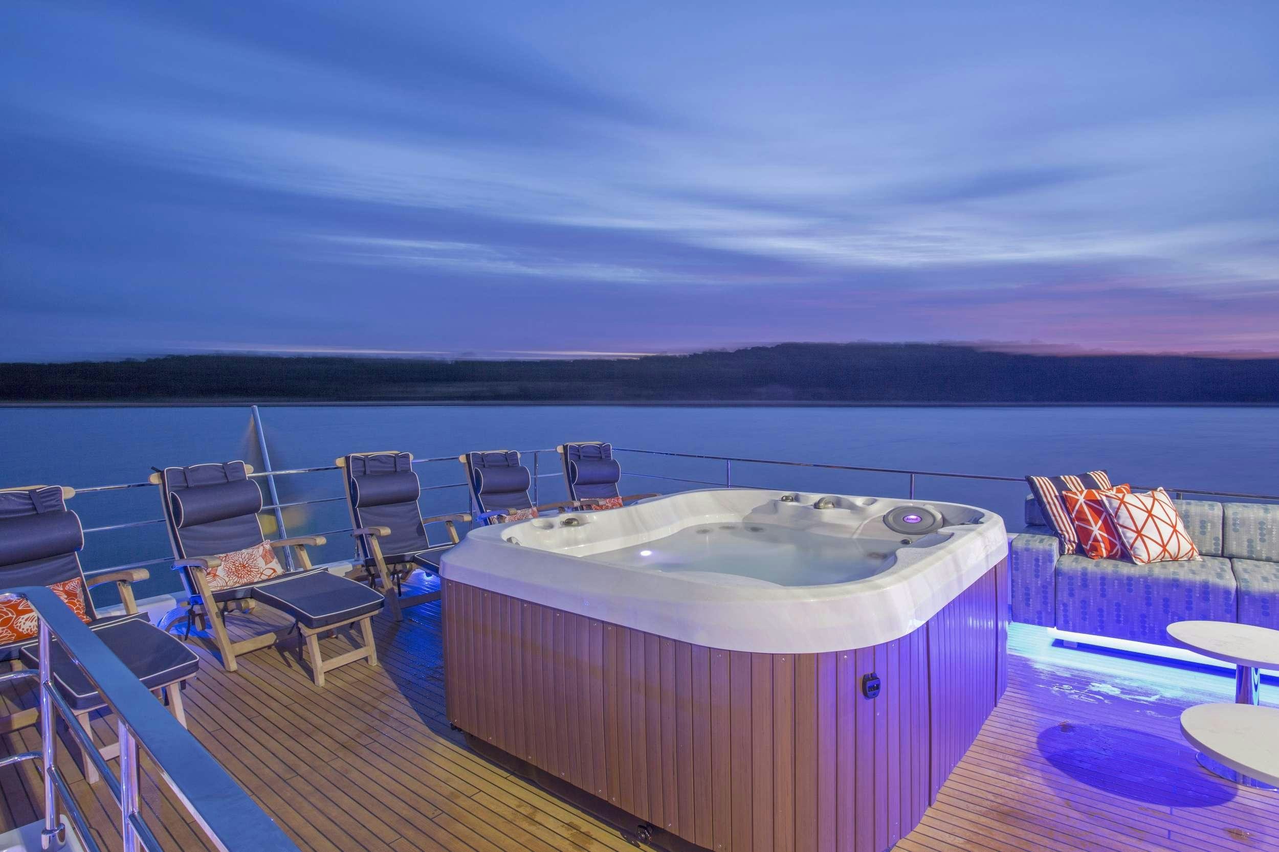 a large pool with a deck and chairs on the deck aboard ALANDREA Yacht for Charter