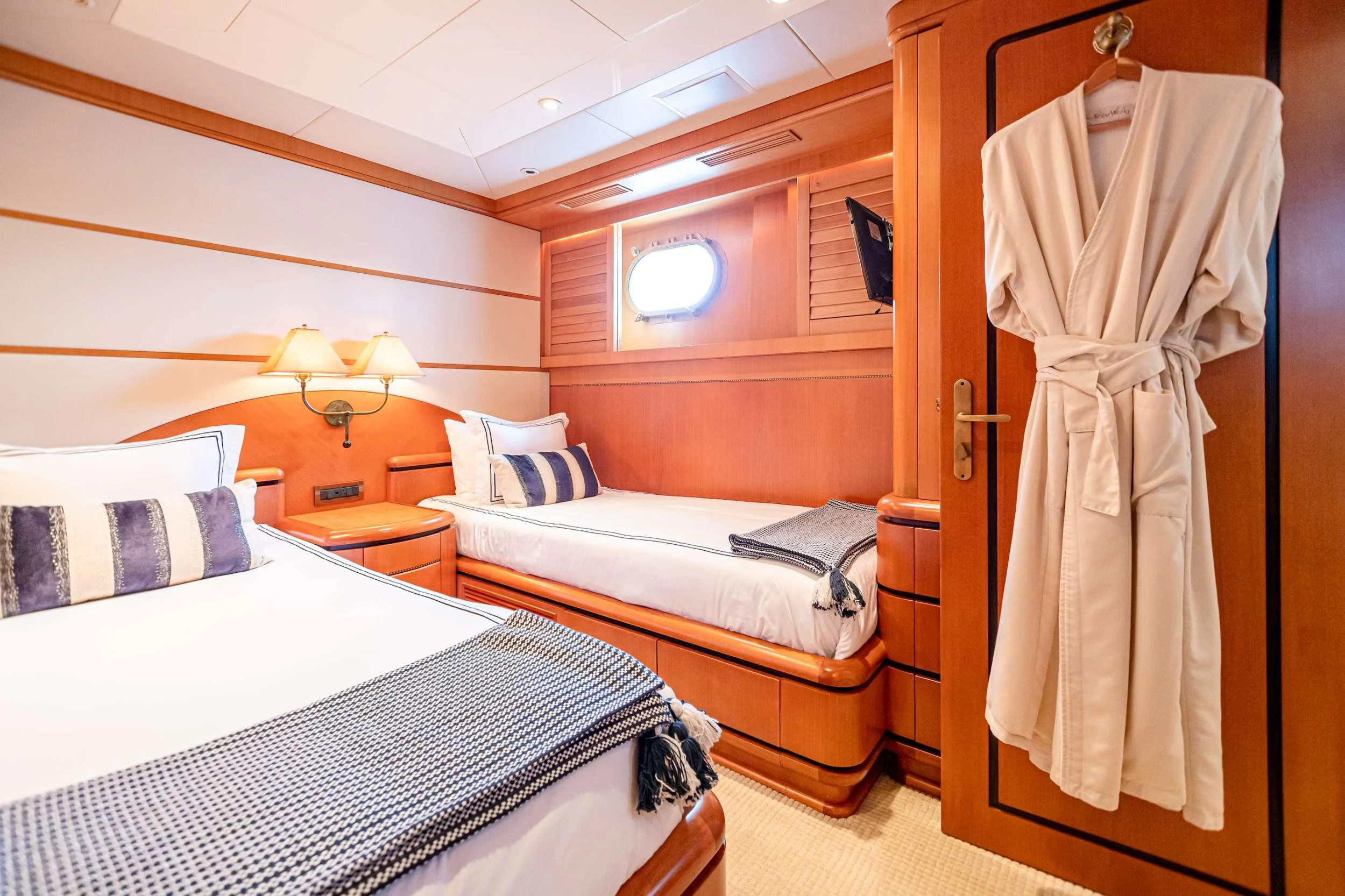 a room with beds and a closet aboard XOXO (118') Yacht for Charter