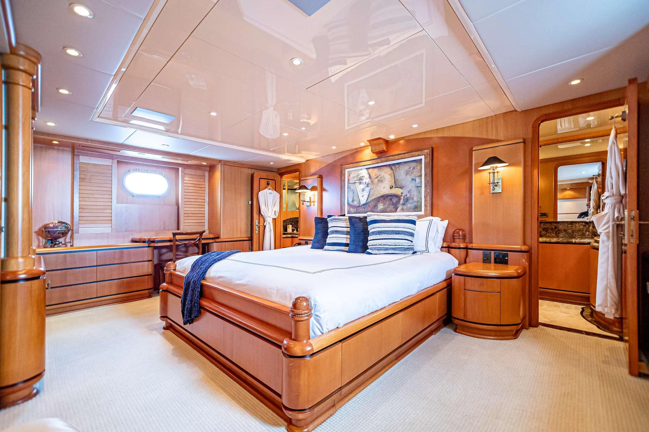 a bedroom with a bed and a mirror aboard XOXO (118') Yacht for Charter