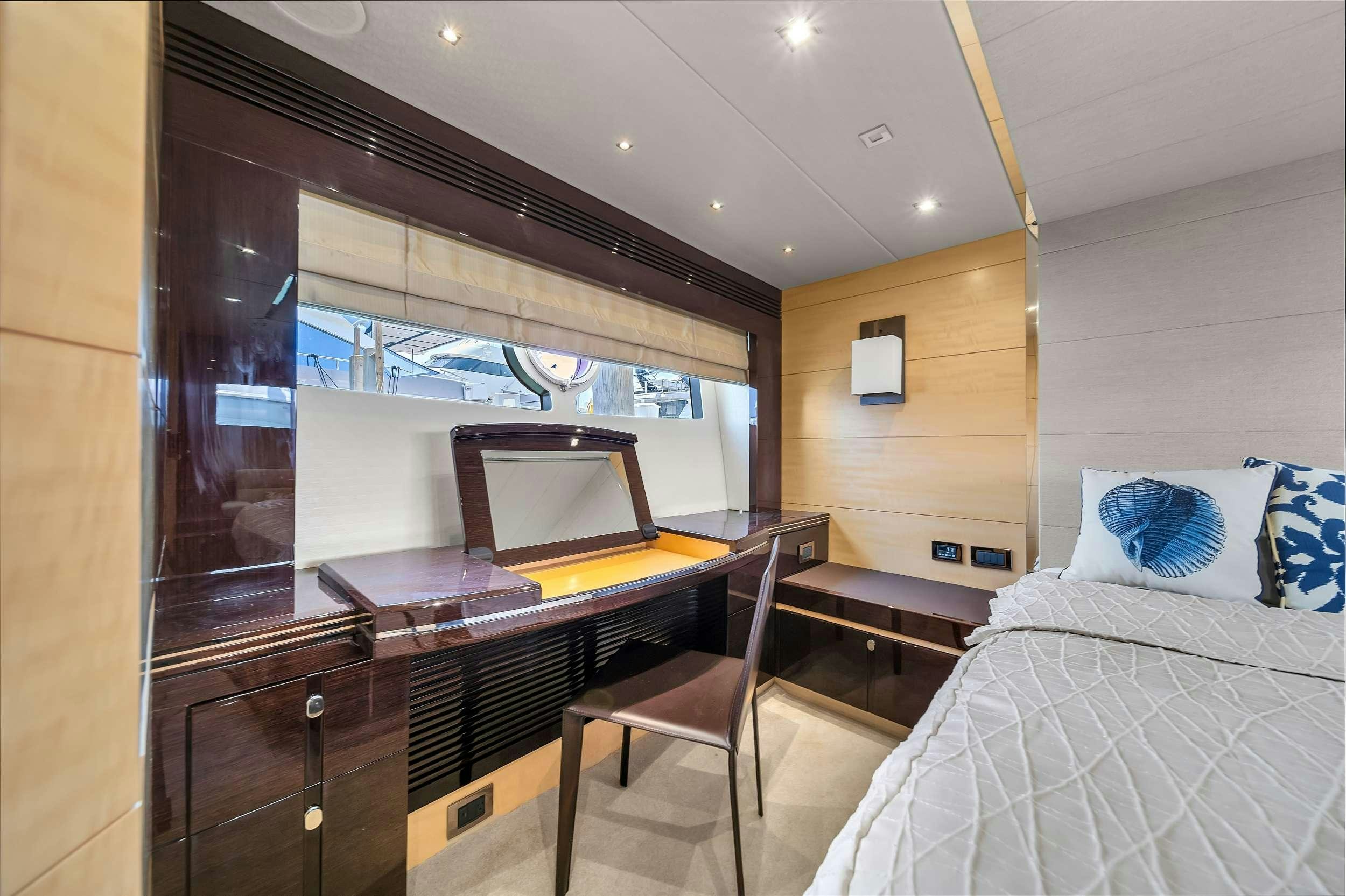 a bedroom with a bed and desk aboard GEM Yacht for Charter