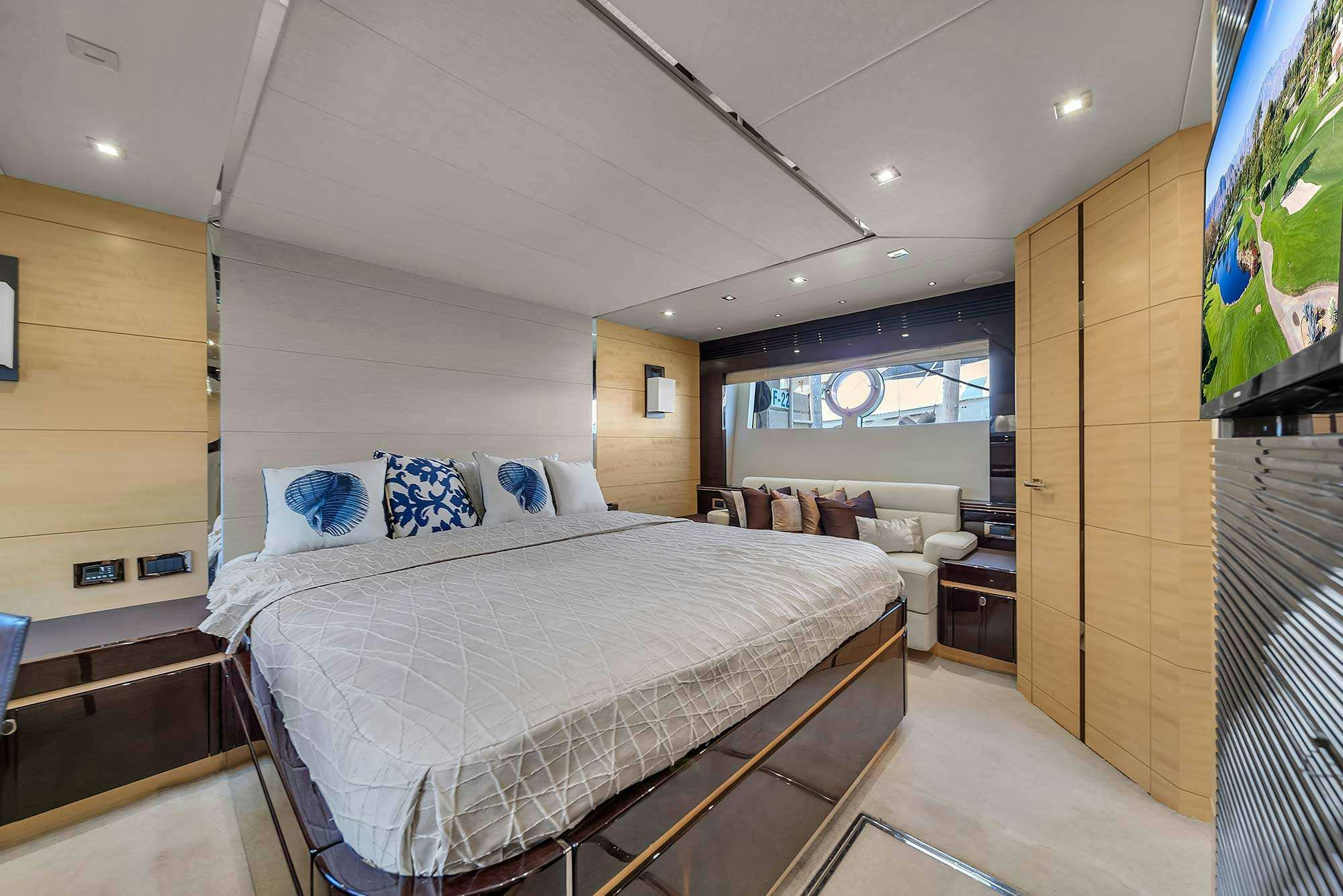 a bedroom with a bed and a television aboard GEM Yacht for Charter