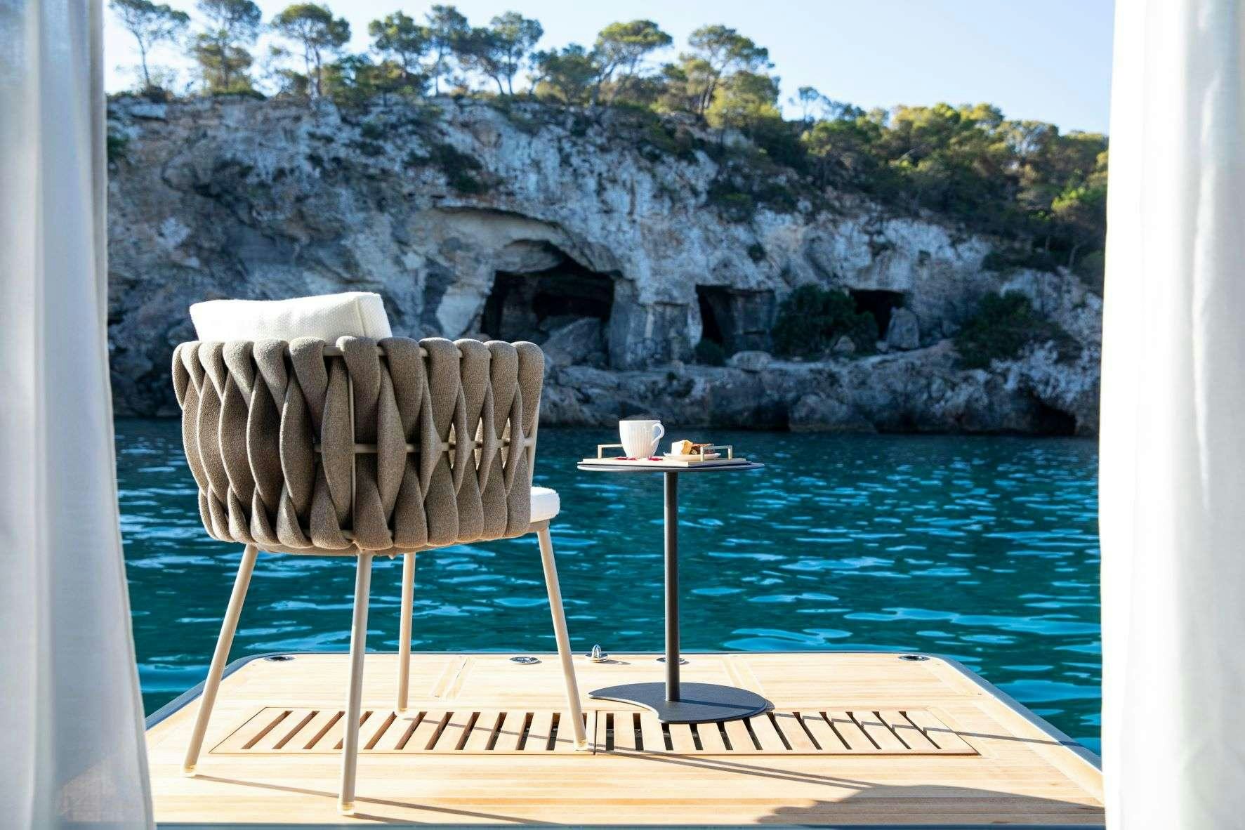 a chair and a table by a pool aboard SASTA Yacht for Charter