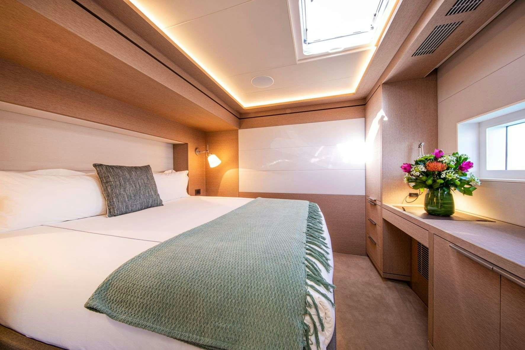 a bed with a white bed spread aboard SASTA Yacht for Charter