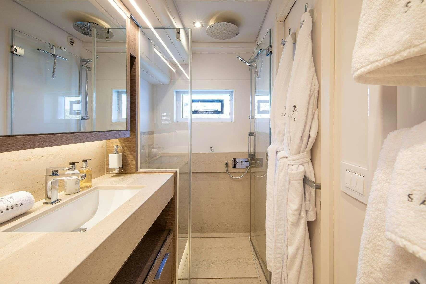 a bathroom with a shower and sink aboard SASTA Yacht for Charter