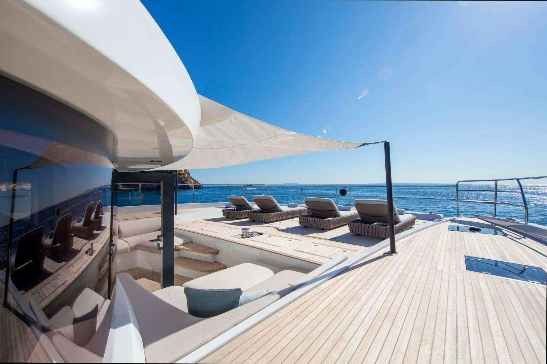a lounge chair on a deck overlooking the ocean aboard SASTA Yacht for Charter