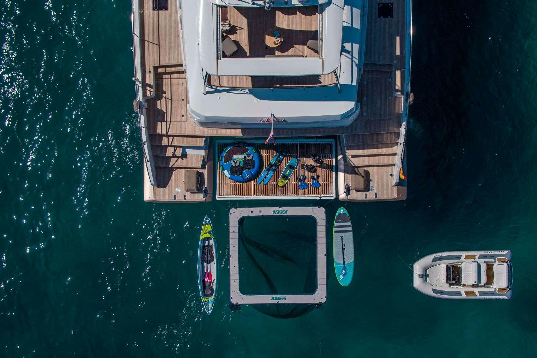 a boat with a deck and a boat on the water aboard SASTA Yacht for Charter