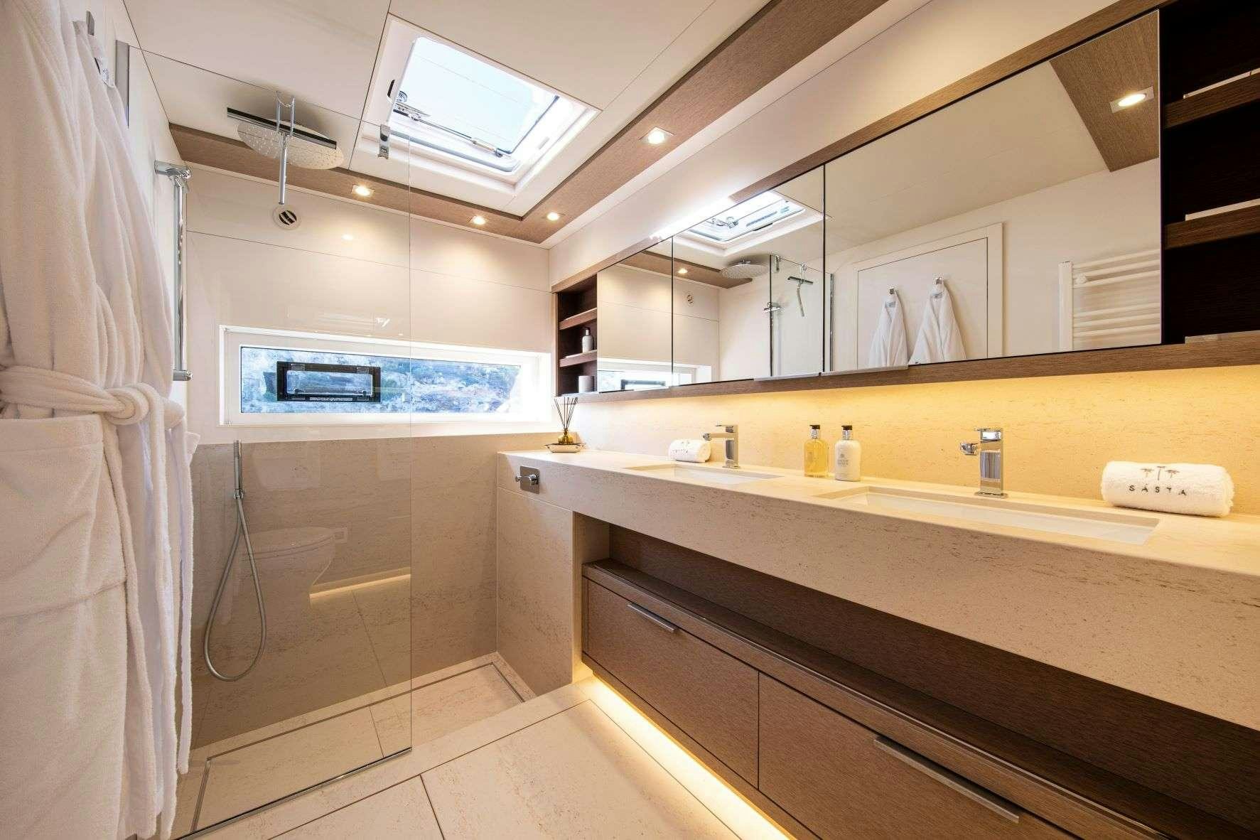 a bathroom with a countertop sink and a mirror aboard SASTA Yacht for Charter