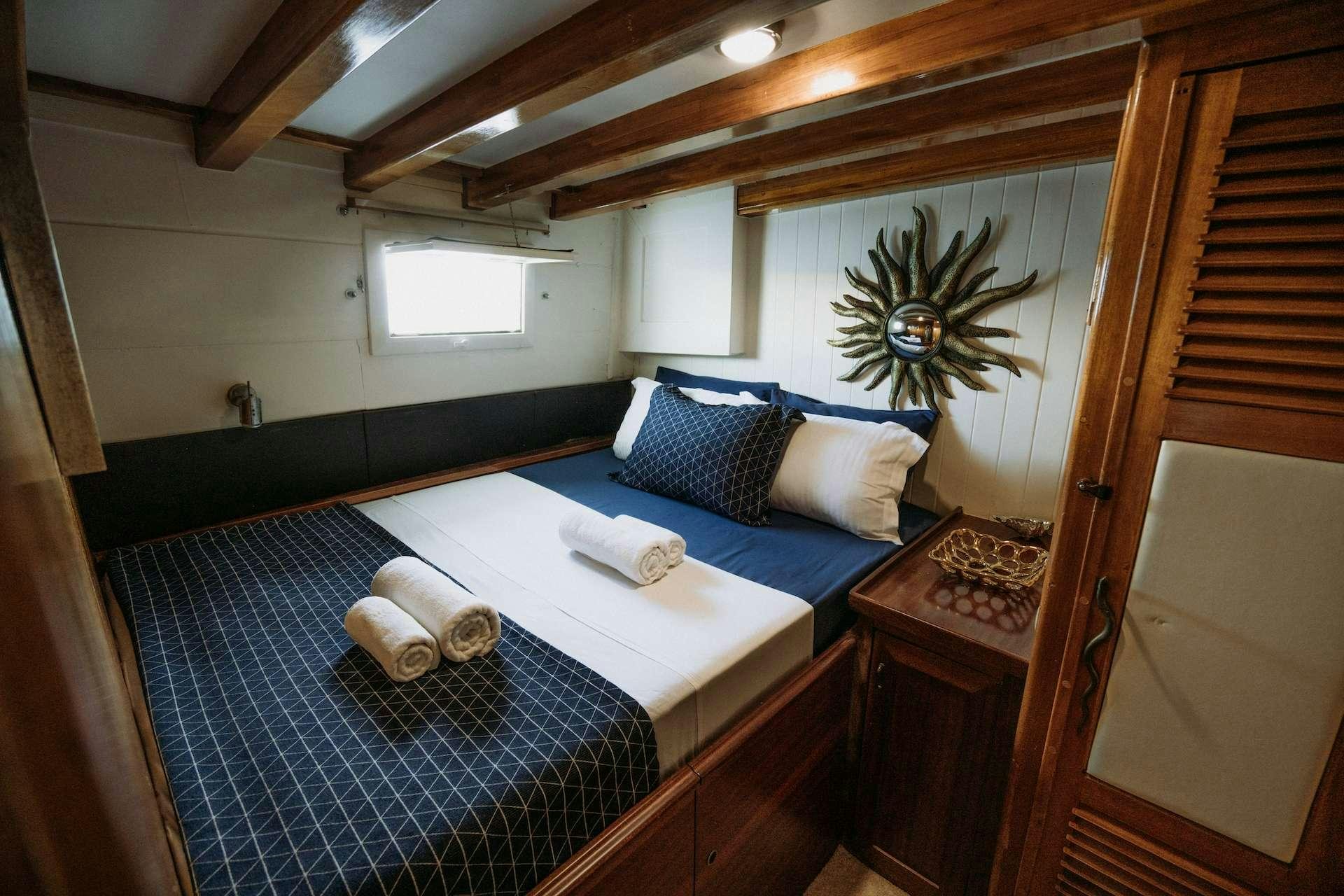 a bed with blue sheets aboard BEYAZ LALE Yacht for Charter