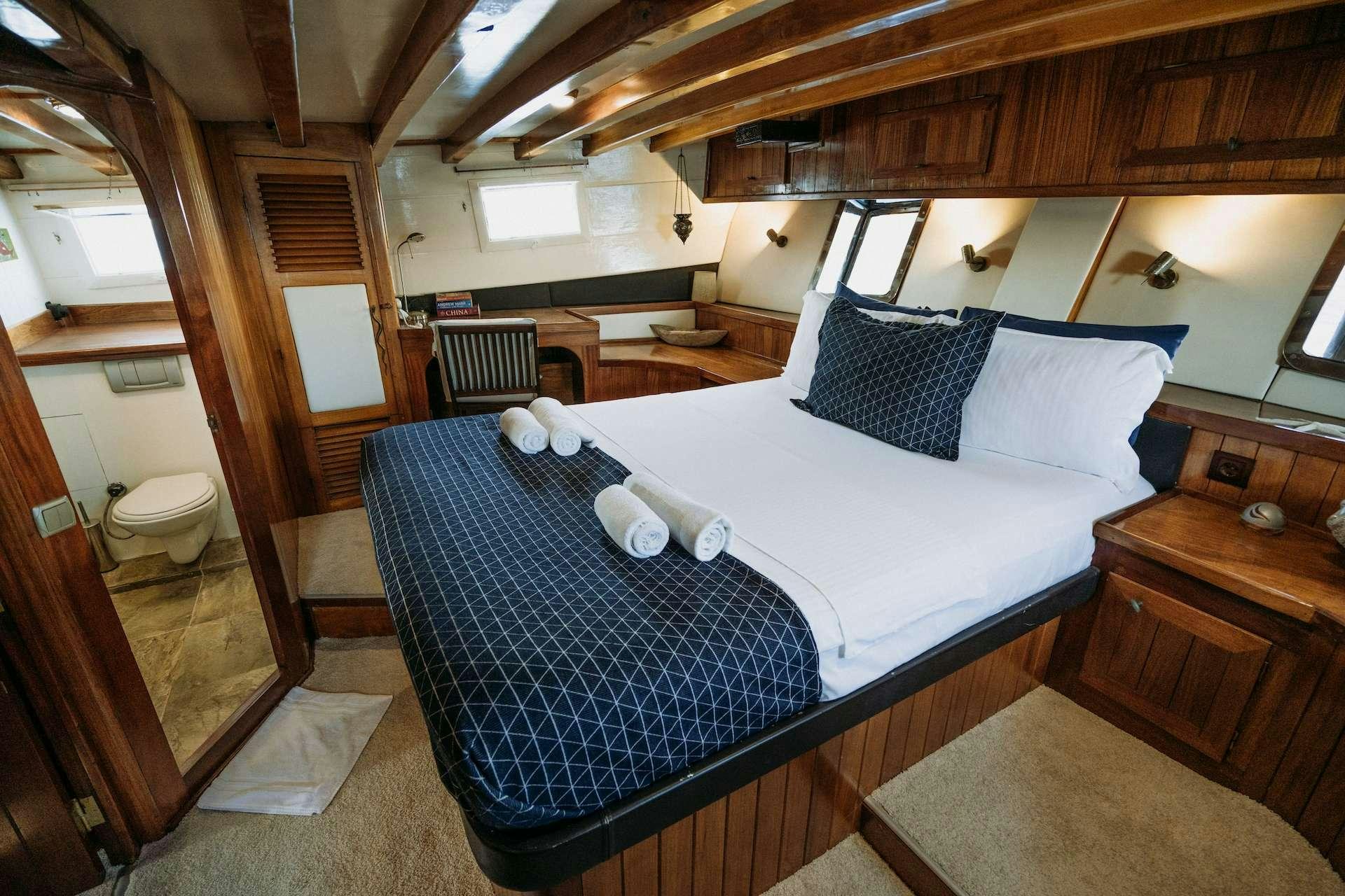 a bed with blue sheets aboard BEYAZ LALE Yacht for Charter