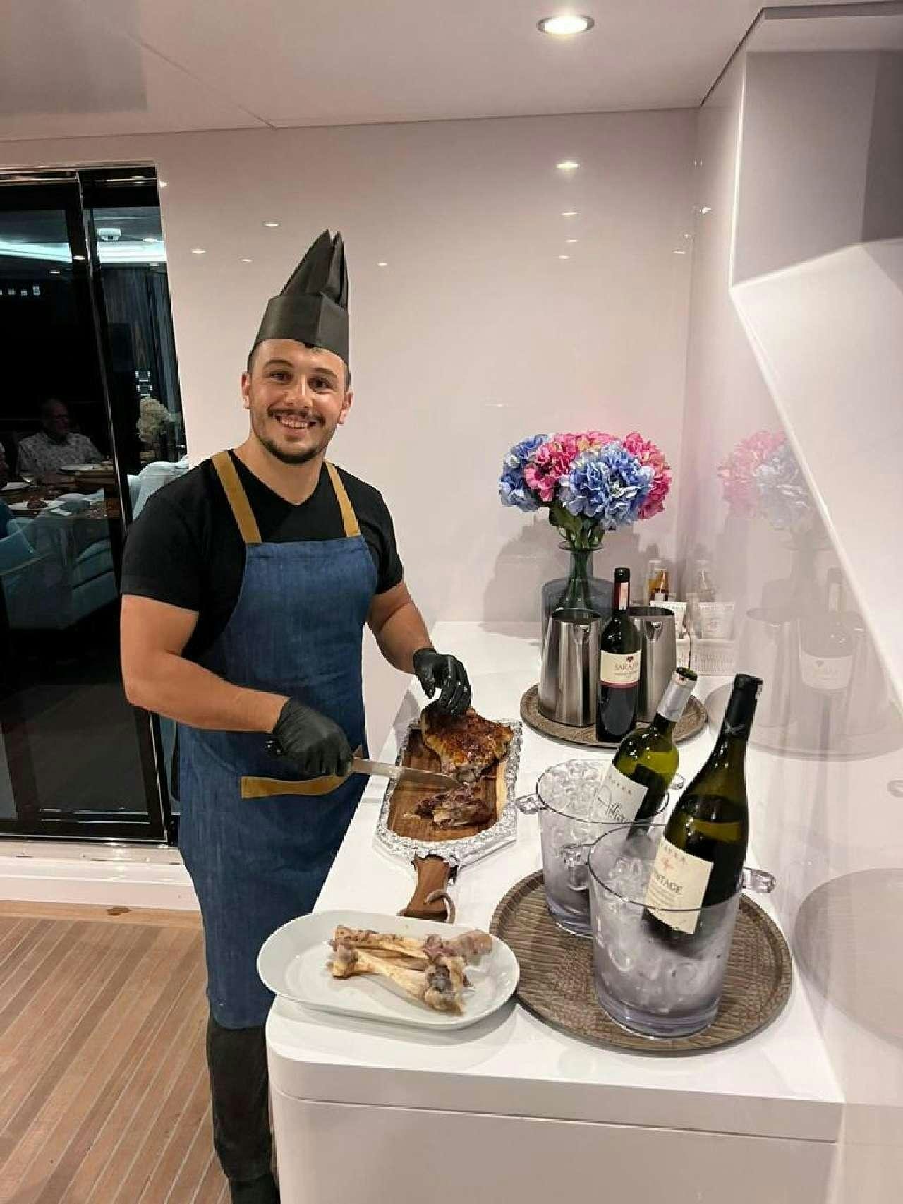 a woman in a costume standing next to a table with food and drinks aboard ROMEO FOXTROT Yacht for Charter