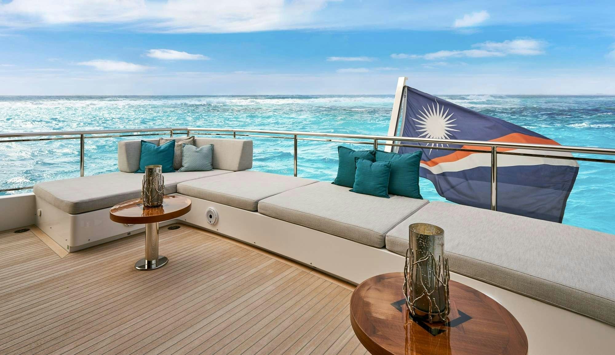 a large white couch with a table in front of it aboard ROMEO FOXTROT Yacht for Charter