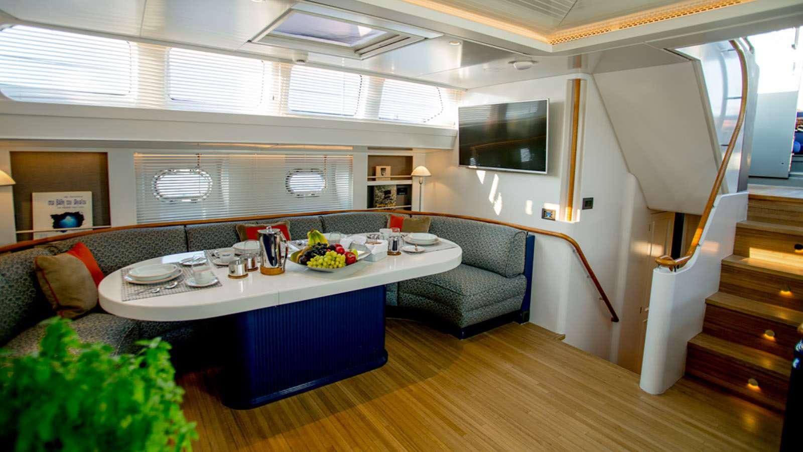 a room with a table and couch aboard AFAET Yacht for Charter