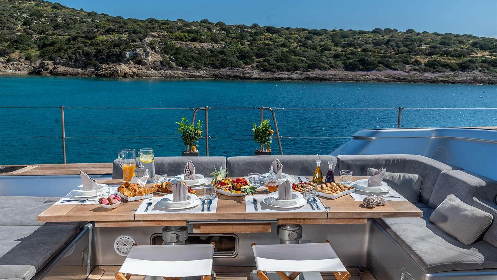 a table with plates and drinks on it by a body of water aboard BLACK LION Yacht for Charter