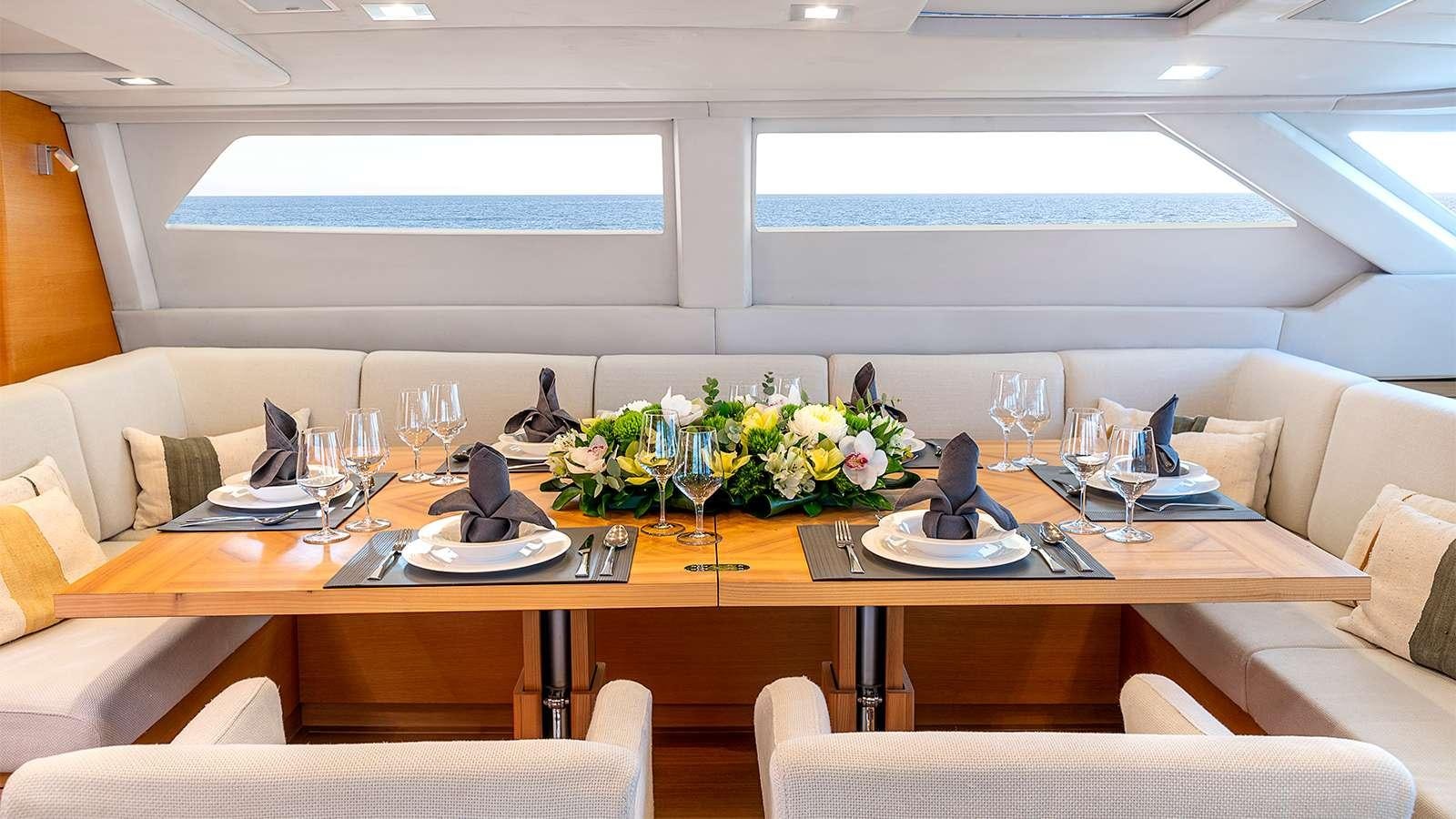 a table with chairs and a vase of flowers on it aboard BLACK LION Yacht for Charter