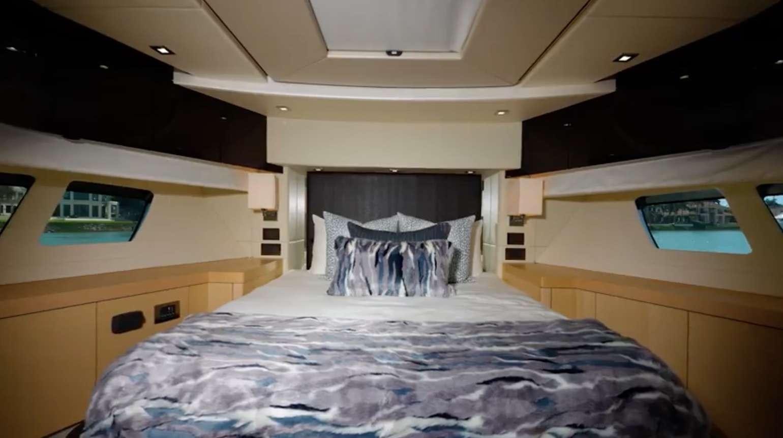 a bed with a blue comforter aboard IT'S ENOUGH Yacht for Charter