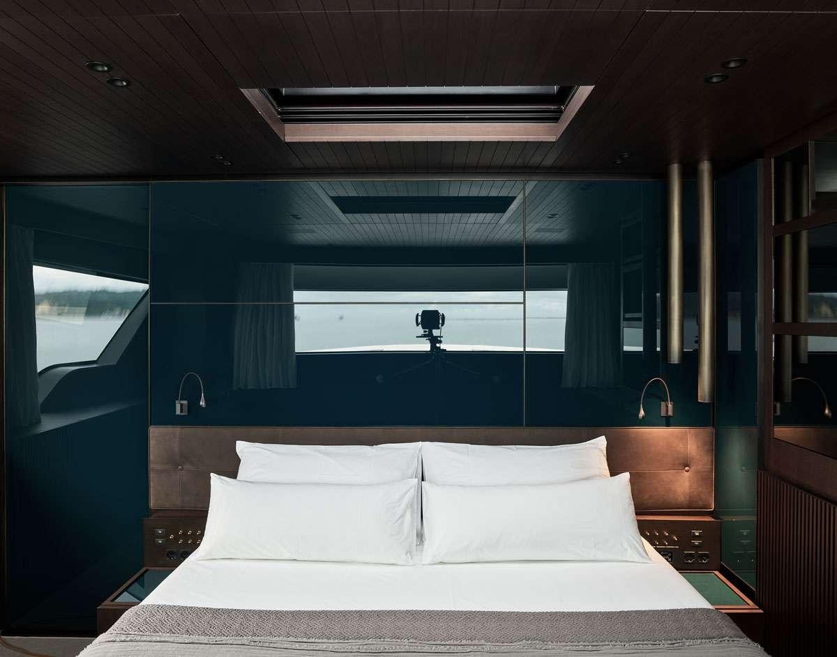 a bed with white sheets aboard LUAR Yacht for Charter