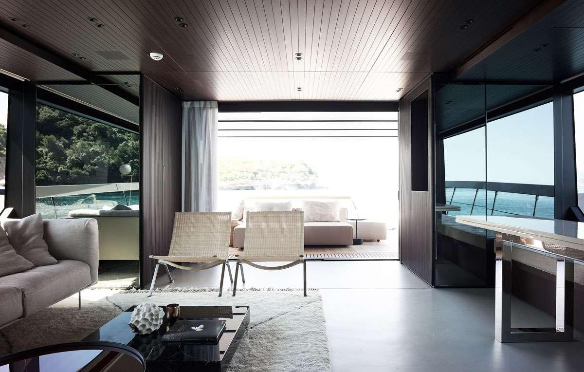 a room with a couch and a table and a window aboard LUAR Yacht for Charter