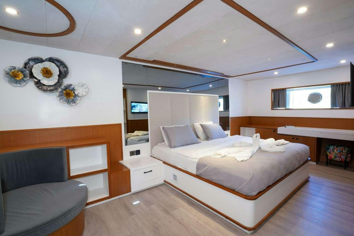 a bedroom with a bed and a chair aboard CINAR YILDIZI Yacht for Charter