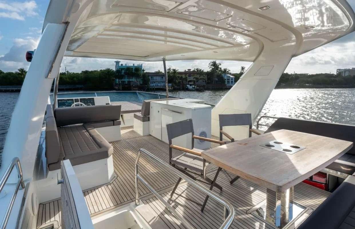 a deck with a table and chairs on it aboard VIMA Yacht for Charter