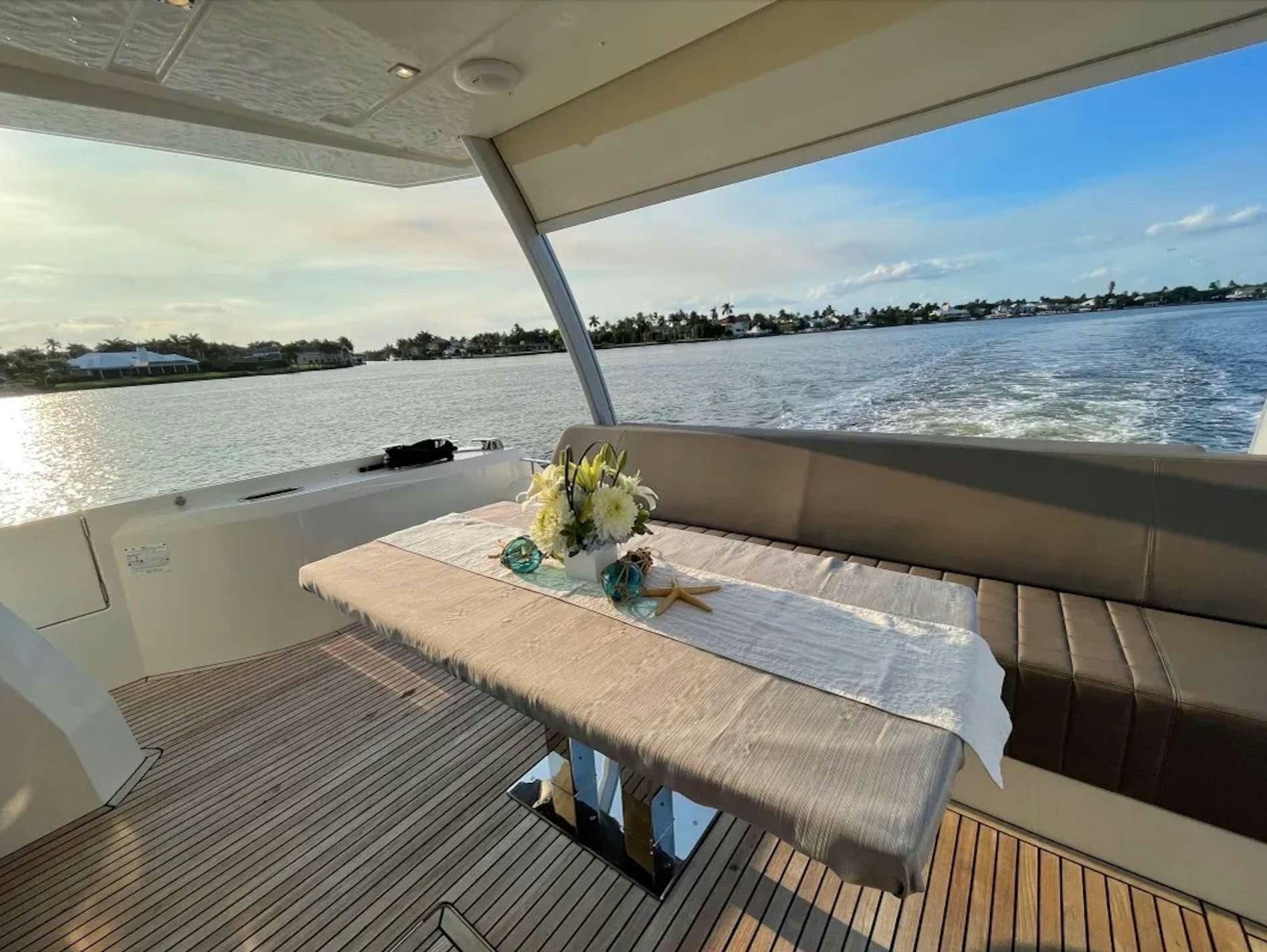 a table on a deck overlooking a body of water aboard VIMA Yacht for Charter