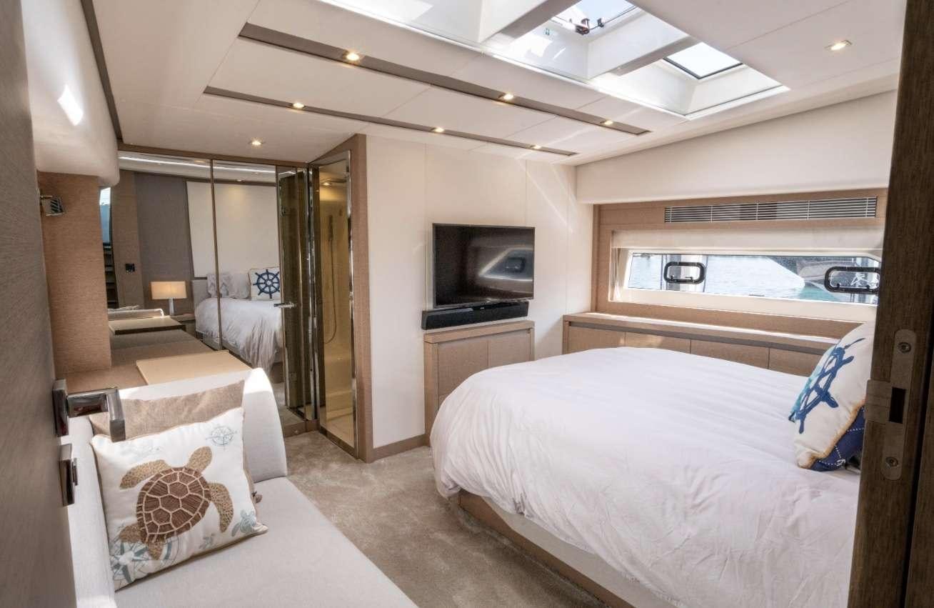 a bedroom with a bed and a television aboard VIMA Yacht for Charter