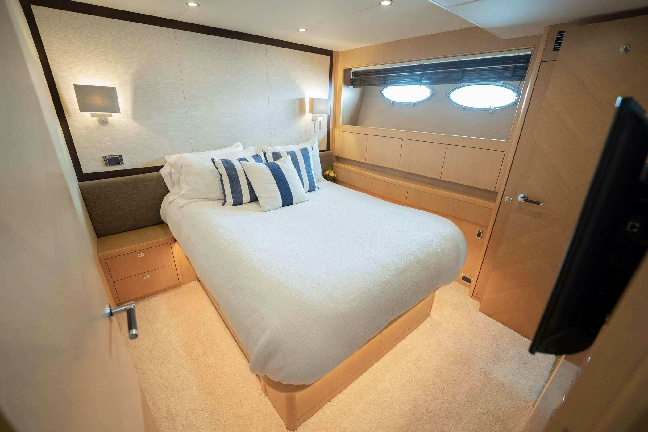 a room with a bed and a mirror aboard NO CURFEW Yacht for Charter