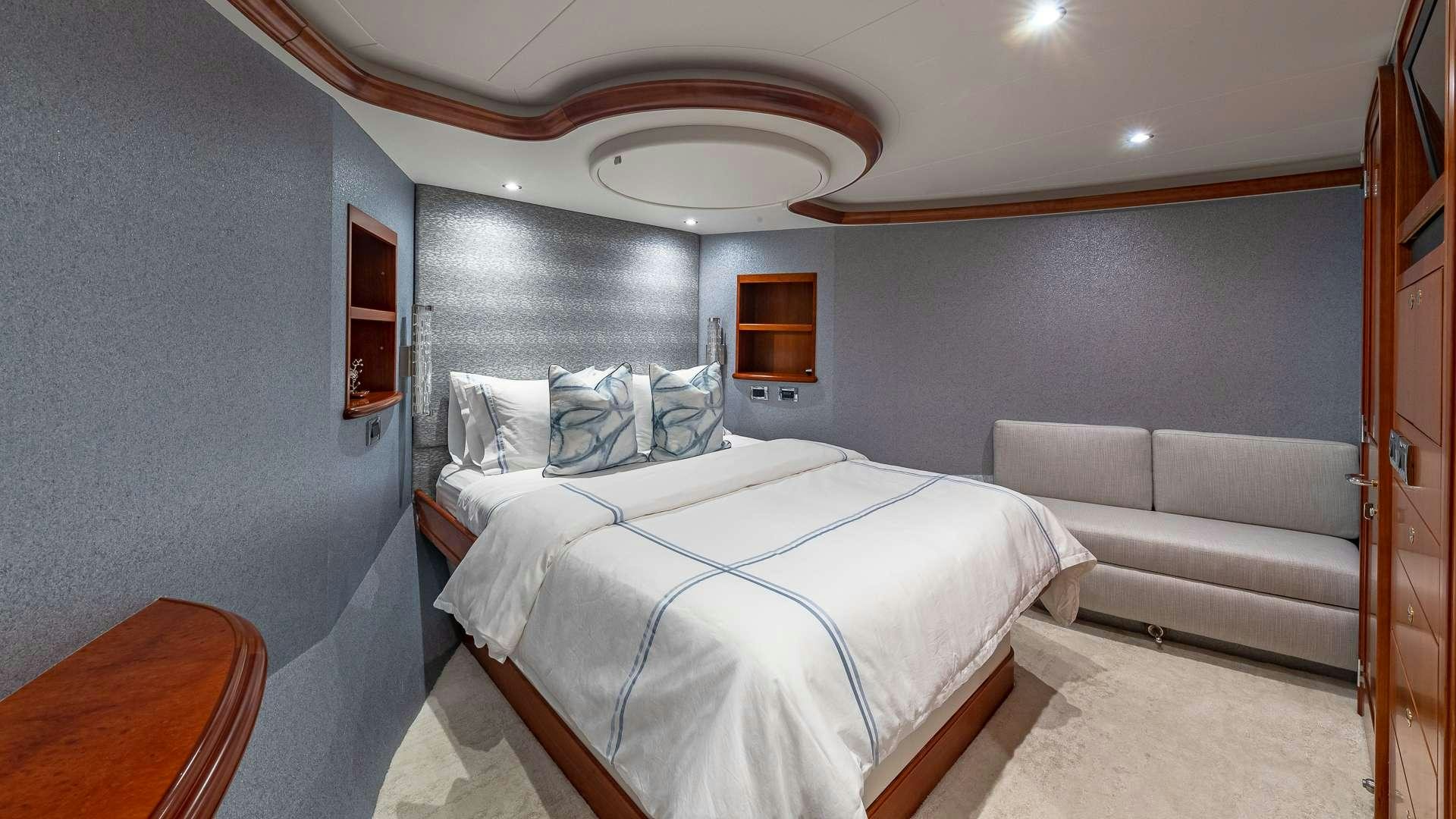 a bedroom with a bed and a couch aboard NO SHORTCUTS Yacht for Charter