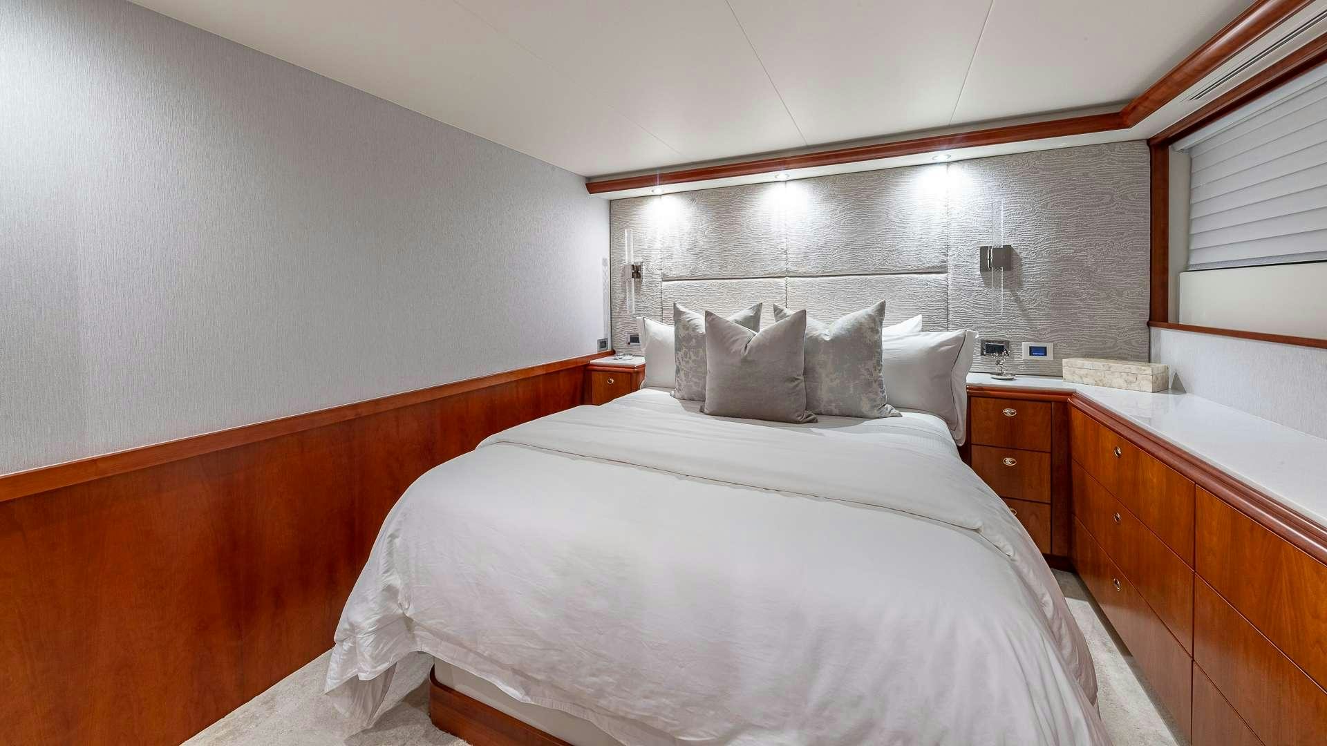 a room with a bed and a dresser aboard NO SHORTCUTS Yacht for Charter
