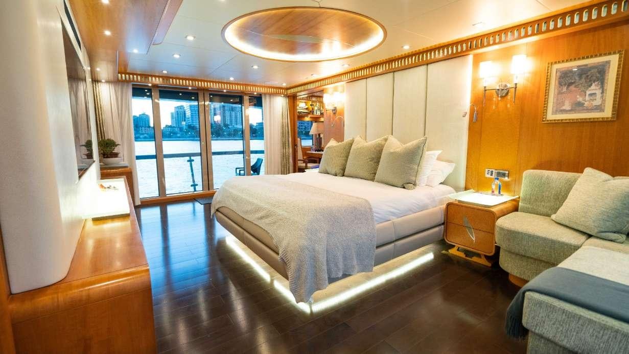 a room with a bed and a couch aboard SERENITY Yacht for Charter