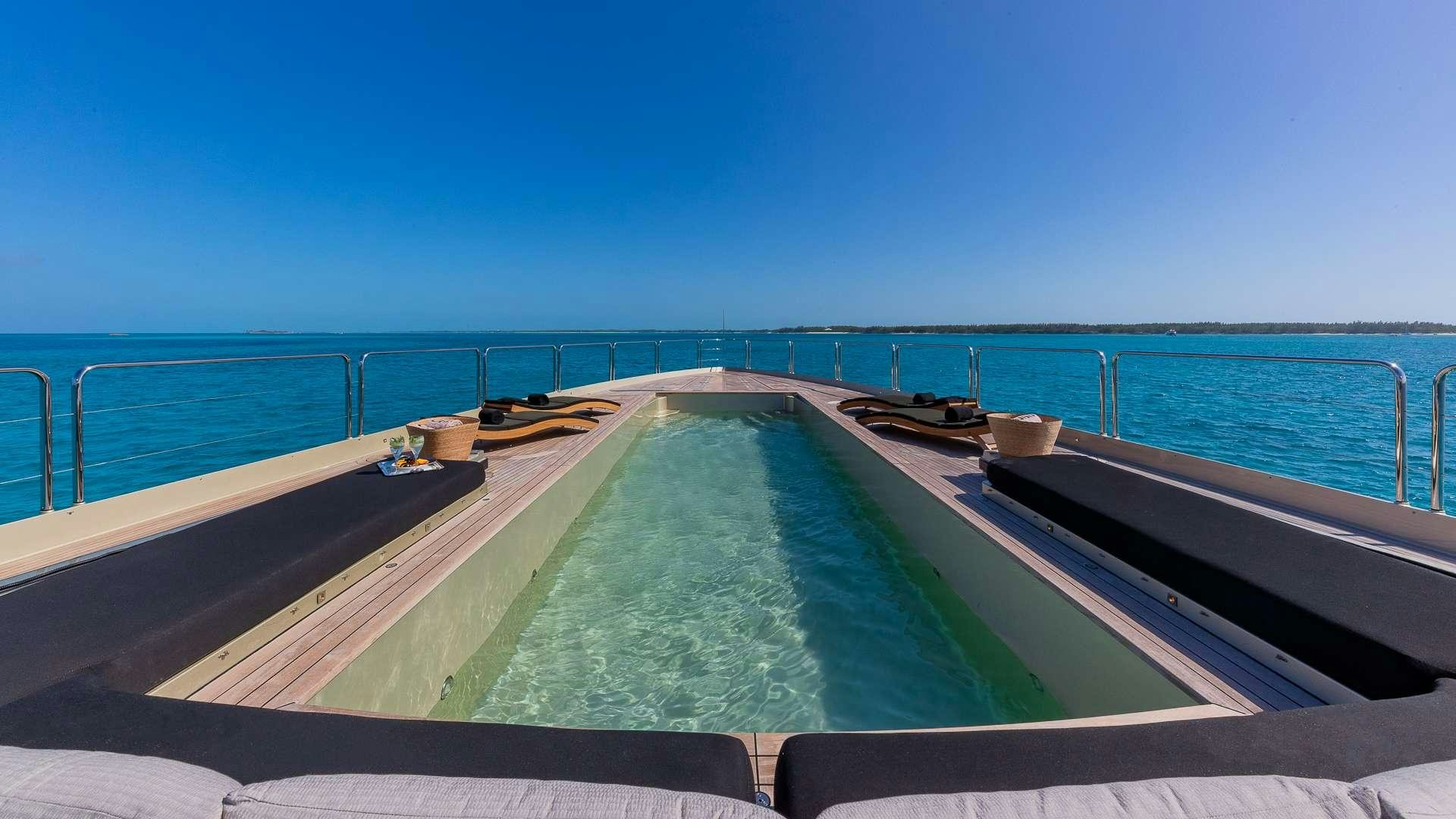 a pool with a deck and a view of the ocean aboard DB9 Yacht for Charter
