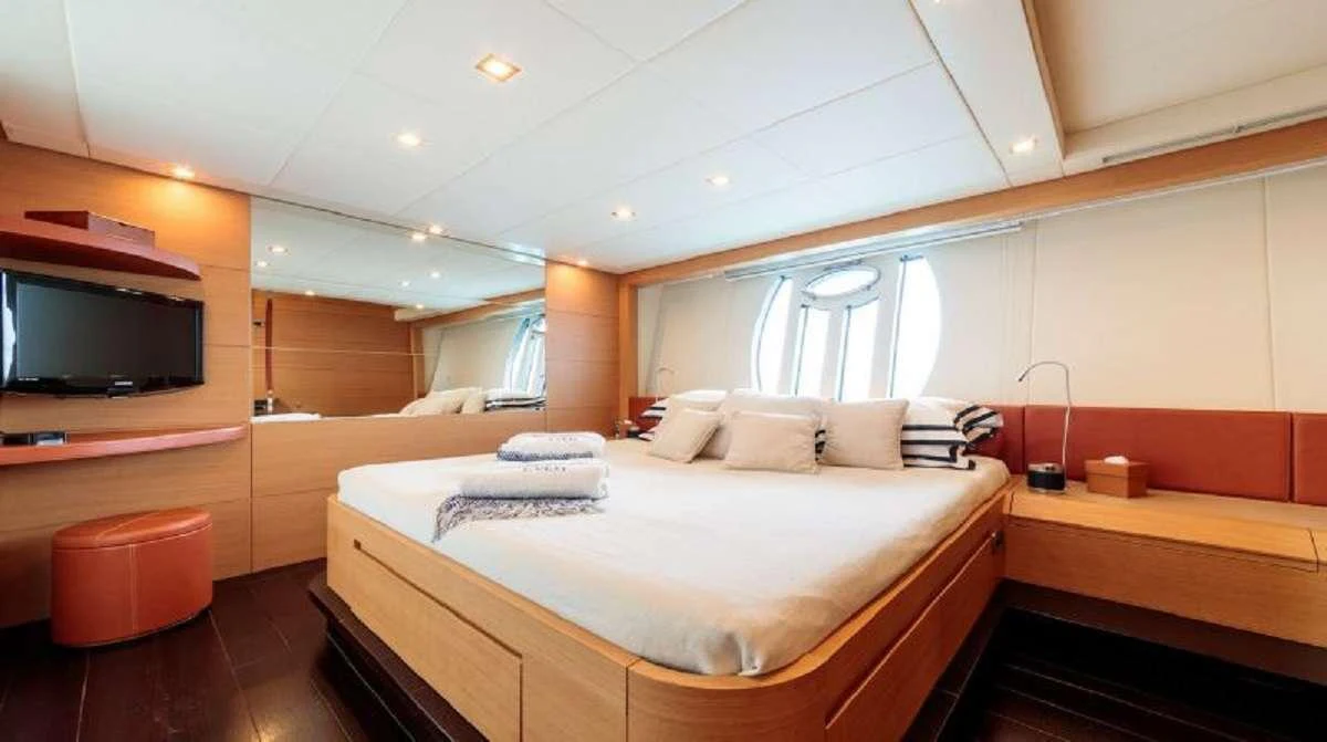 a room with a bed and a television aboard FOR EVER Yacht for Charter