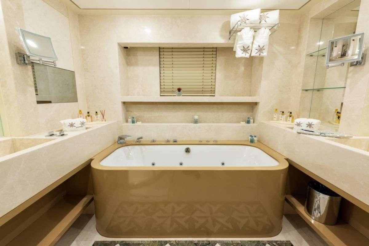 a bathroom with a tub and sinks aboard ARESTEAS Yacht for Charter
