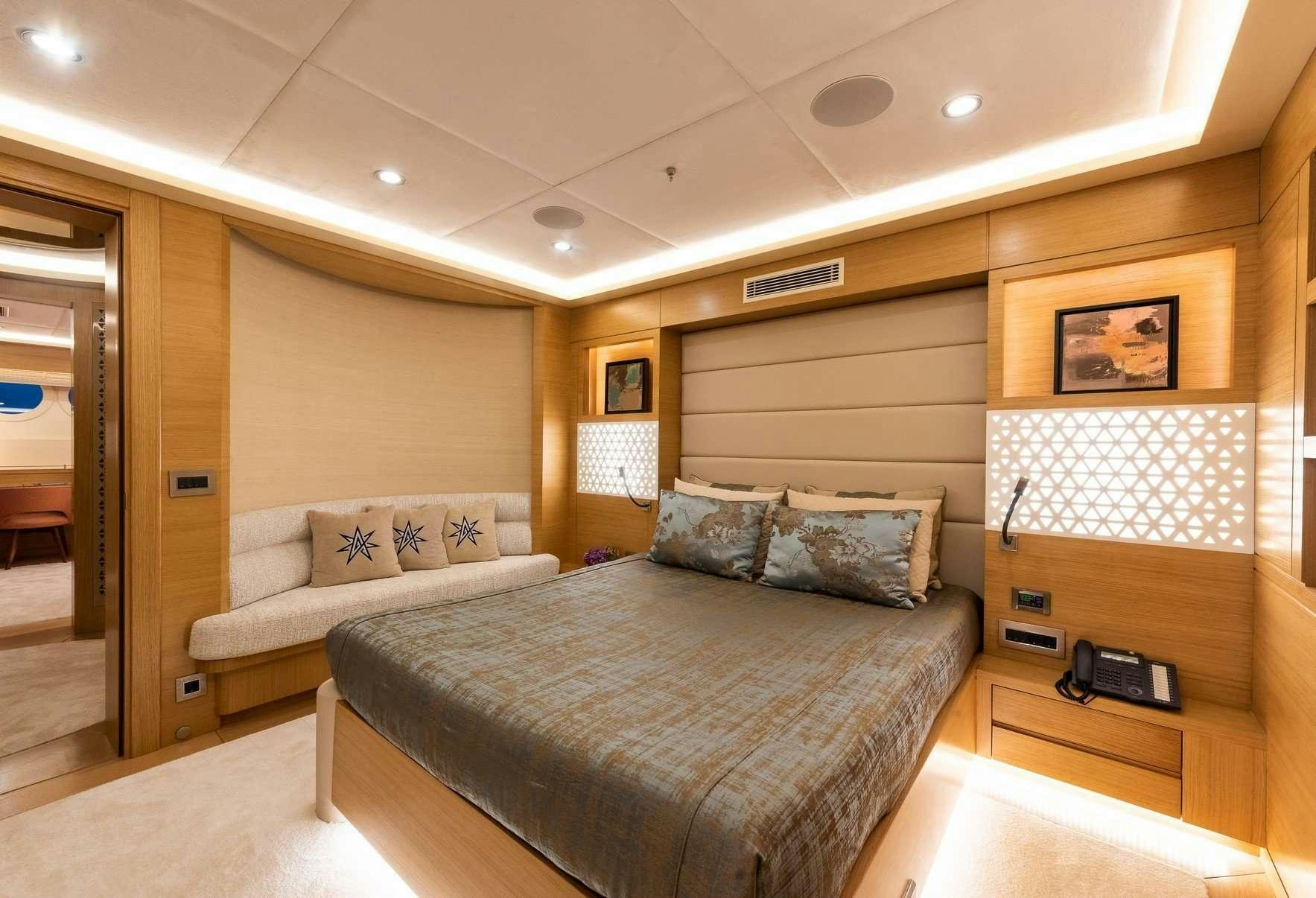 a room with a bed and a phone on the table aboard ARESTEAS Yacht for Charter