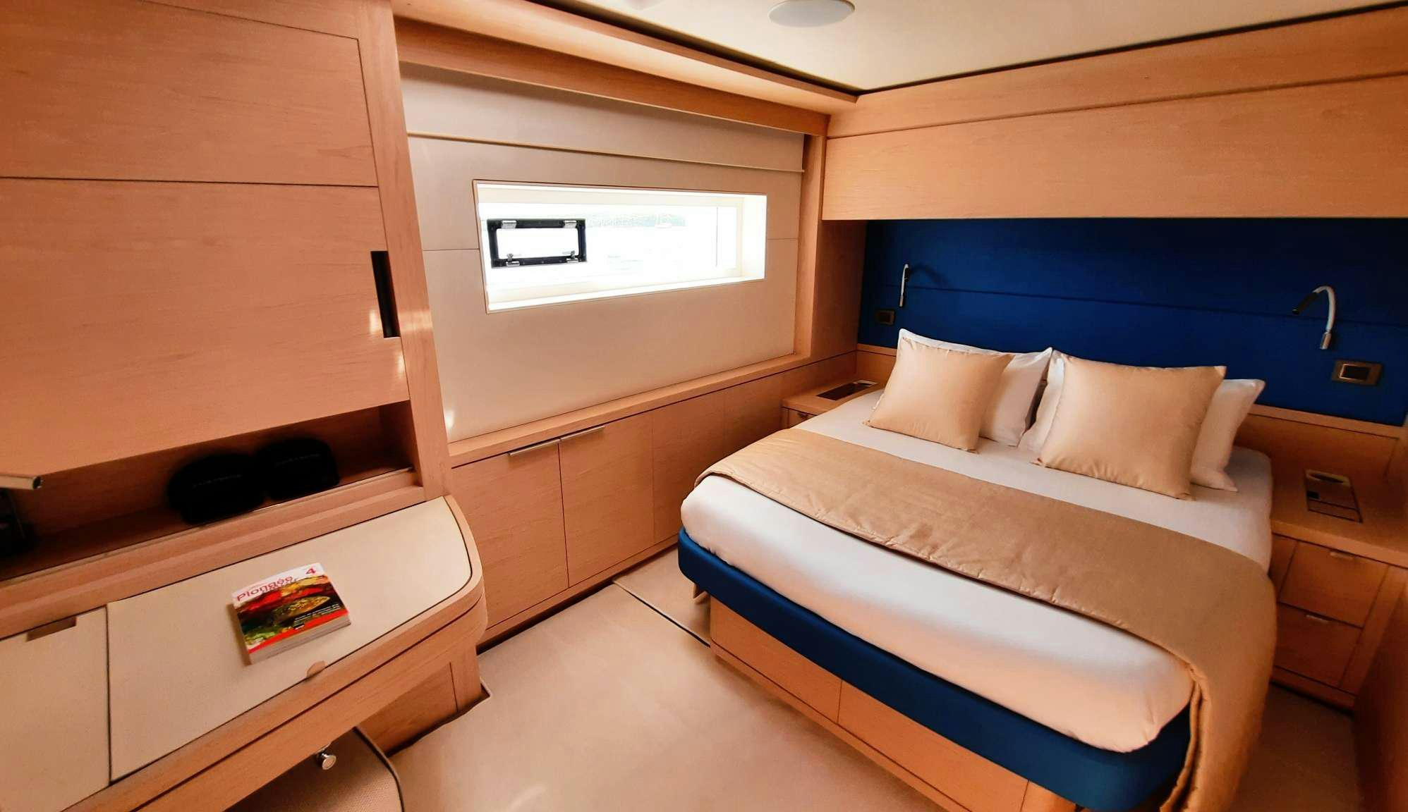 a room with a bed and a desk aboard MANE ET NOCTE Yacht for Charter