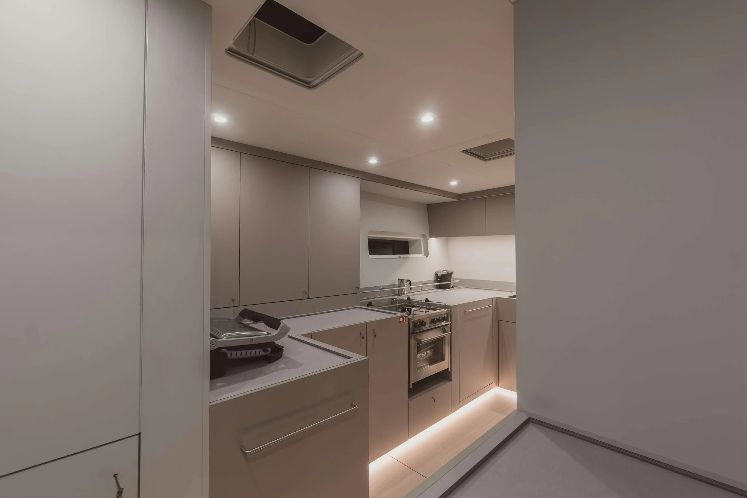 a kitchen with white cabinets aboard NADAMAS Yacht for Charter